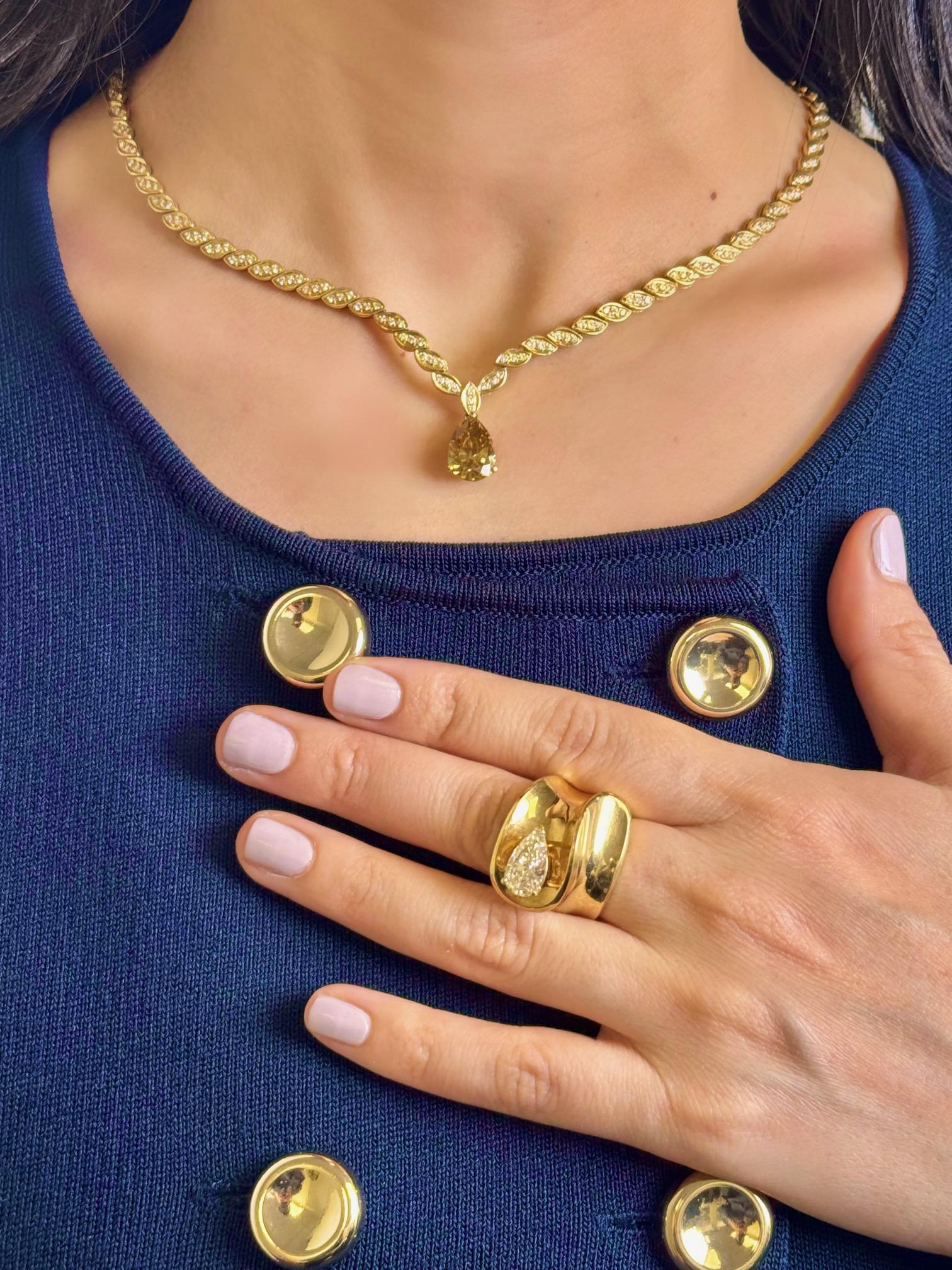 Confectionné en or jaune 18 carats lumineux, ce collier raffiné est orné d'un captivant diamant en forme de poire de 3,55 carats à la teinte brun-jaune unique, rayonnant de chaleur et de profondeur. La pierre centrale est magnifiquement encadrée par