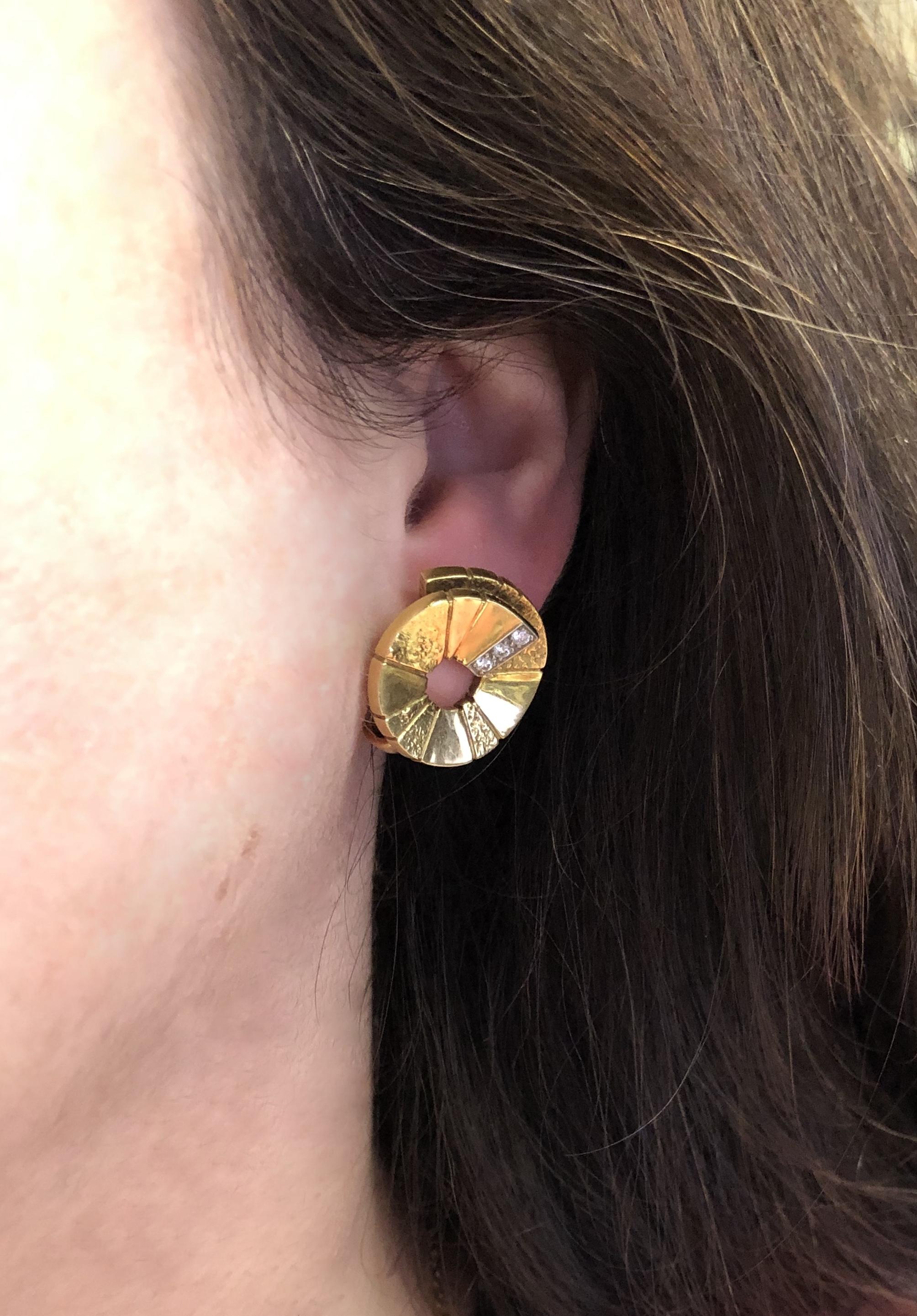 Textured 18 karat yellow gold spirals are accented with a total of approximately 0.25 carat of round diamonds. The earrings are of English origin and bear date marks for 1986.

Diameter: 7/8 inch. Clip backs with posts.