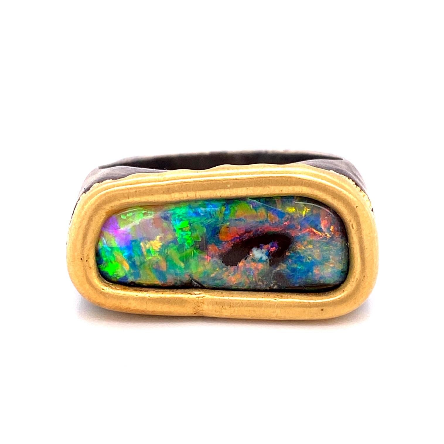 An oxidized sterling silver and 18k yellow gold men's ring set with one freeform 7.6 carat boulder opal. Ring size 11. This ring was made and designed by llyn strong.