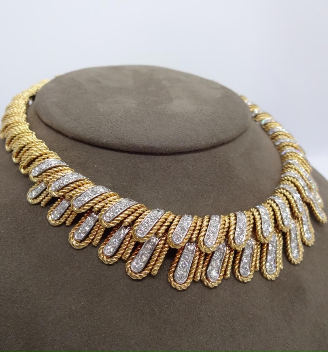 Over 10 carats (approximately 10.85) of round brilliant diamonds are set in platinum and 18K yellow gold layered, twisted wire feathered motif this stylish diamond necklace.  While it currently measures 13.75inches, it can easily be lengthened for