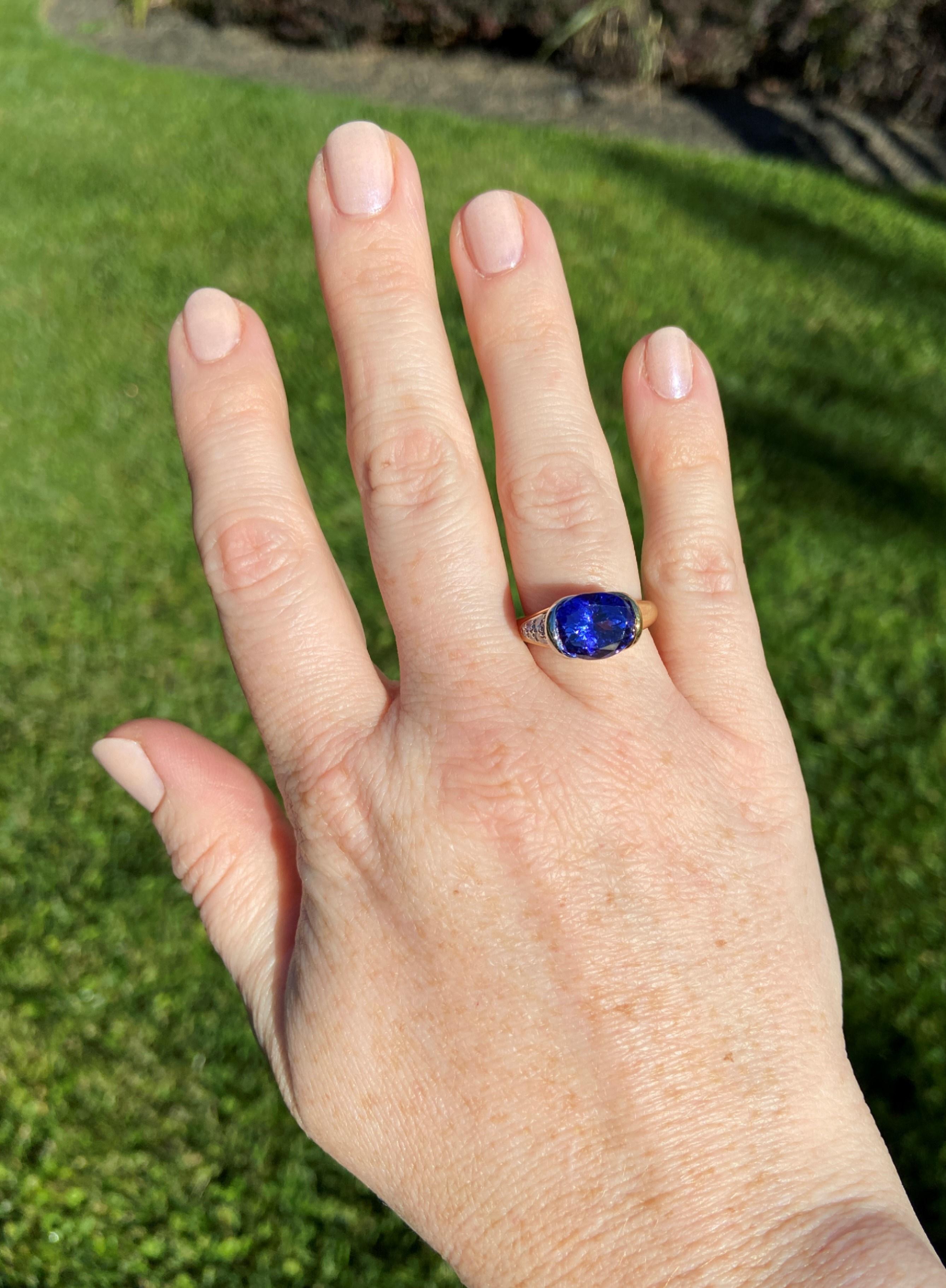 An exceptionally colored 4.5ct tanzanite is held in an east-west setting at the center of this substantial 18K yellow gold and platinum ring. One shoulder of the tanzanite is buttery 18k yellow gold and the other is platinum studded with 0.62tcw of