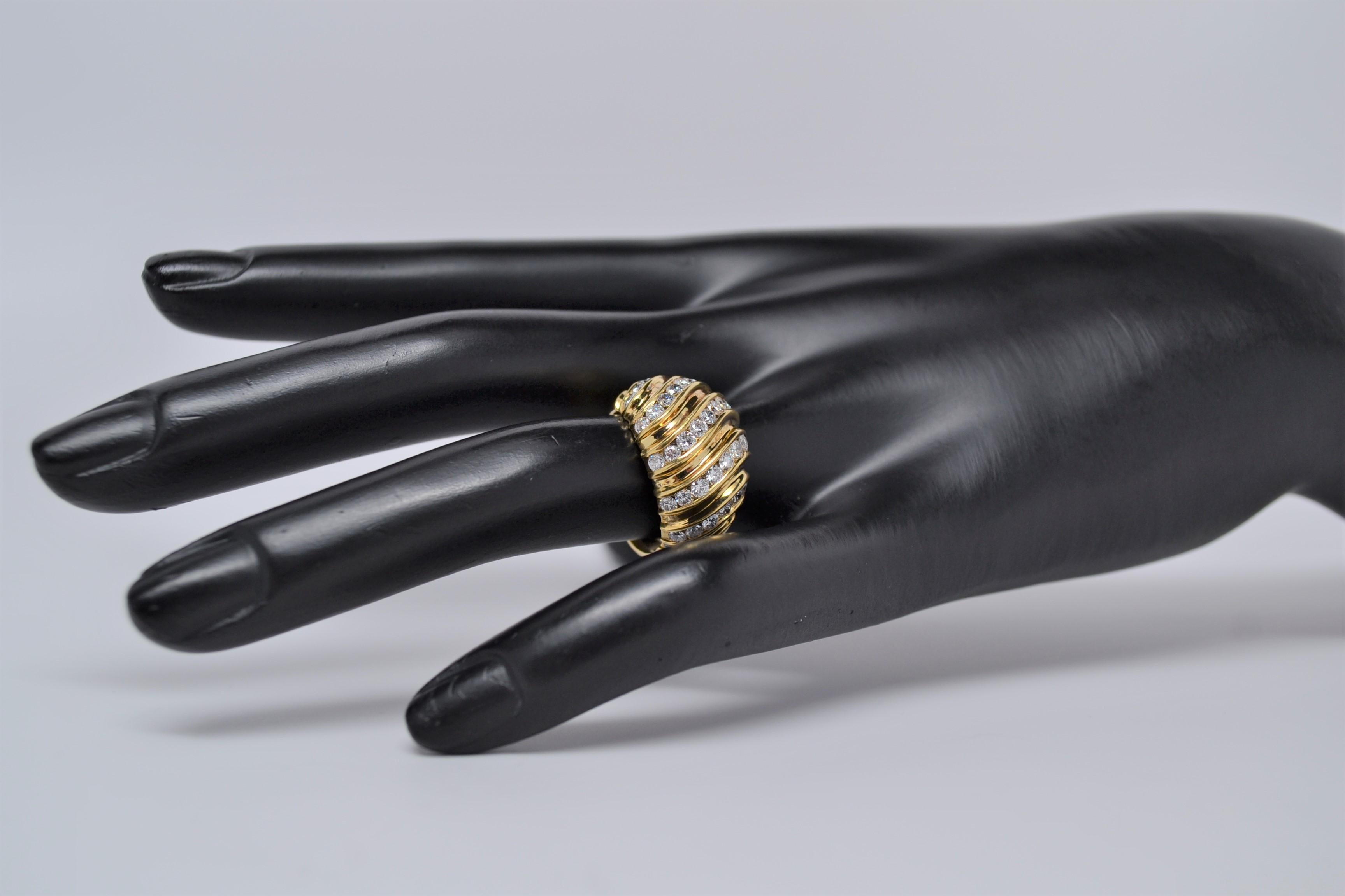 A unique 18K Yellow Gold ring set with Round Brilliant Cut Diamonds. There are five rows of diamonds set in custom channels with a flowing and wavy layout. 
A total of thirty seven Round Brilliant Cut Diamonds weigh 1.55ct. Diamond color grade range