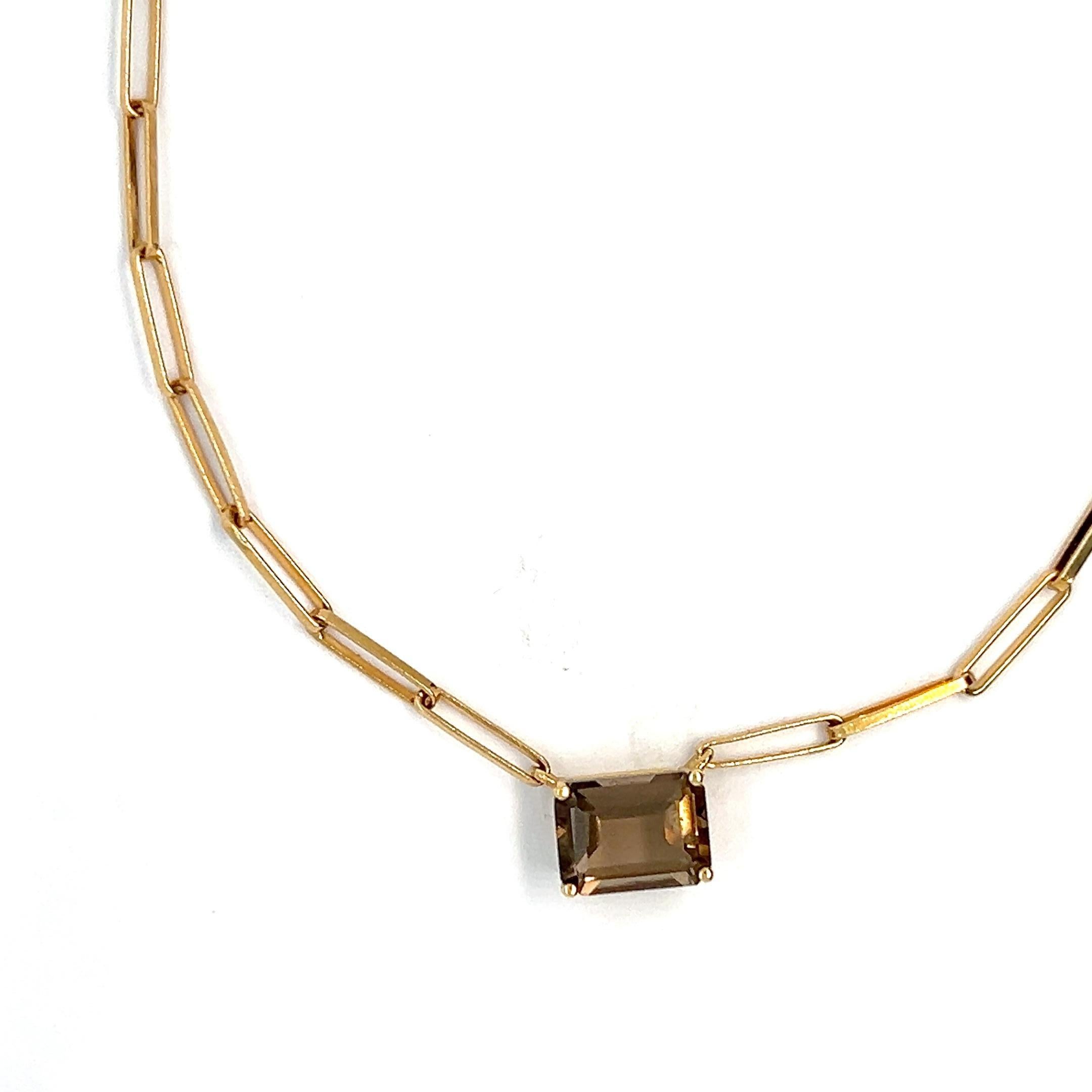 Ce collier exquis incarne l'élégance discrète et la sophistication intemporelle. Réalisé en or jaune 18 carats, il présente l'éclat chaleureux du métal précieux rehaussé par les riches tons du quartz fumé. La pierre précieuse brune translucide