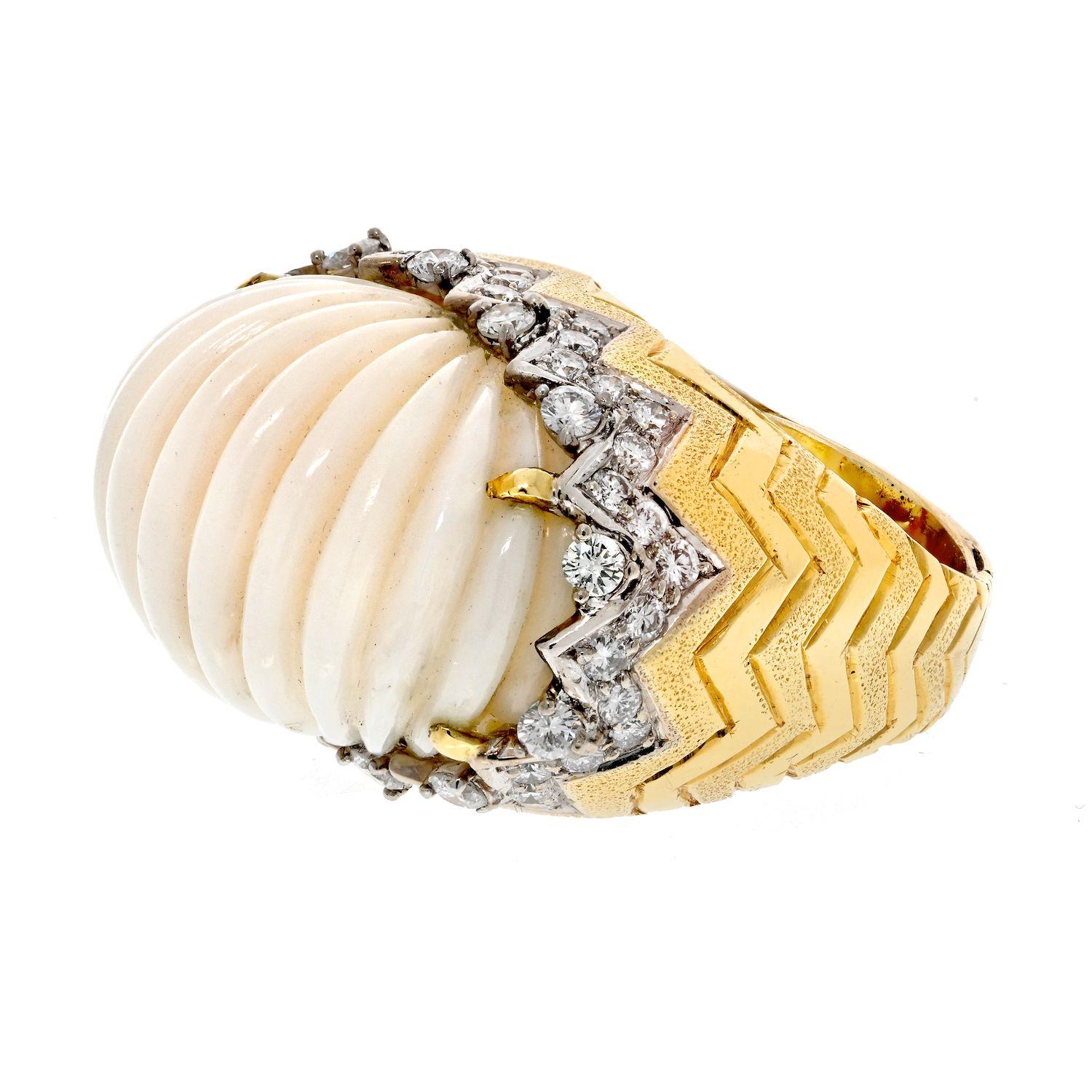 The 18K Yellow Gold Angel Skin Fluted Coral and Diamond Ring is a captivating piece of jewelry that exudes elegance and sophistication. Crafted in 18K yellow gold, this ring features a fluted design adorned with angel skin coral, known for its