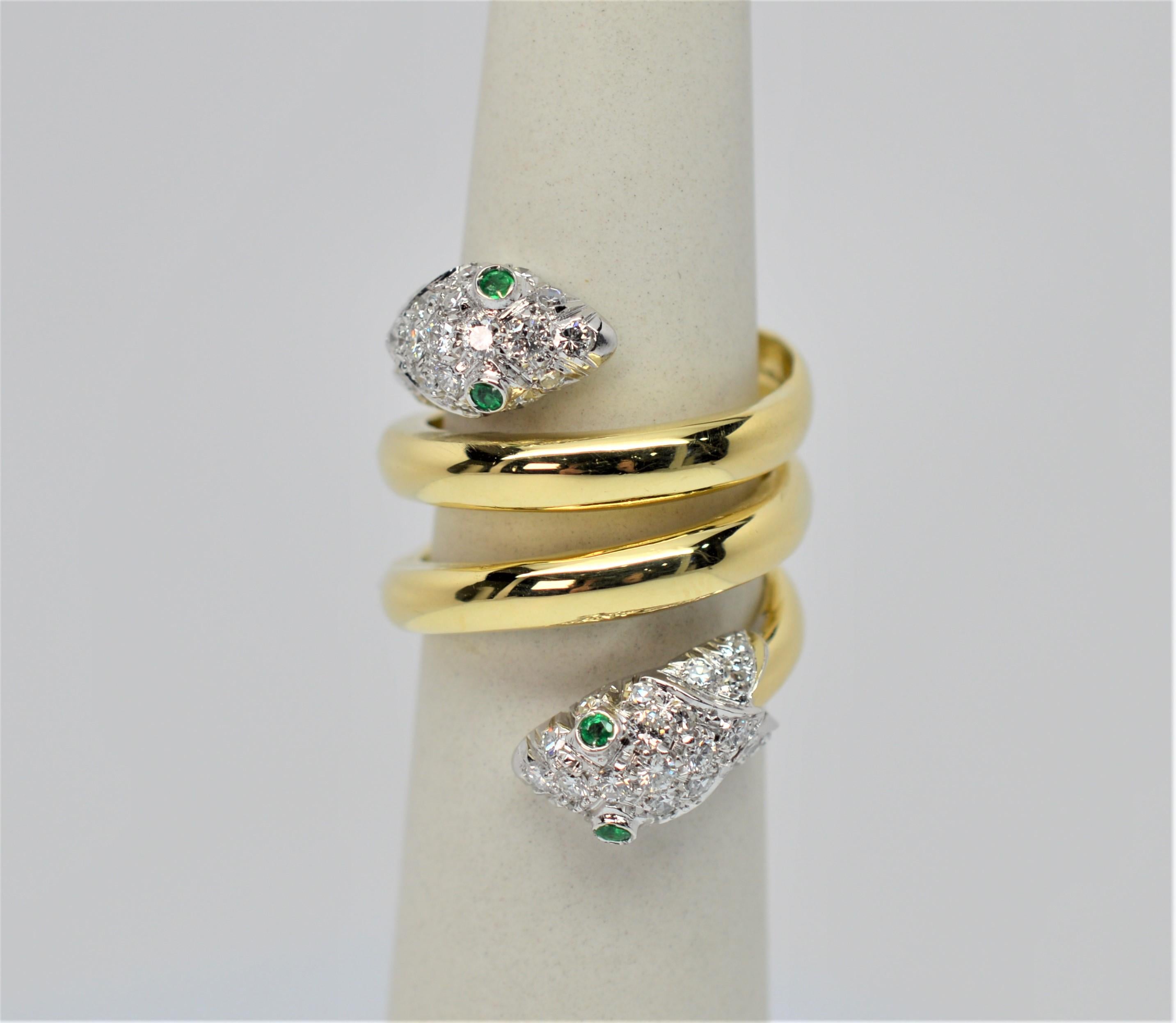 Eighteen karat (18K) yellow gold coils in the shape of a two headed serpent ring. In size 7, diamonds cover each serpent's head and are accented with emerald eyes. The length of this unique coil shaped ring is approximately one inch. This ring is