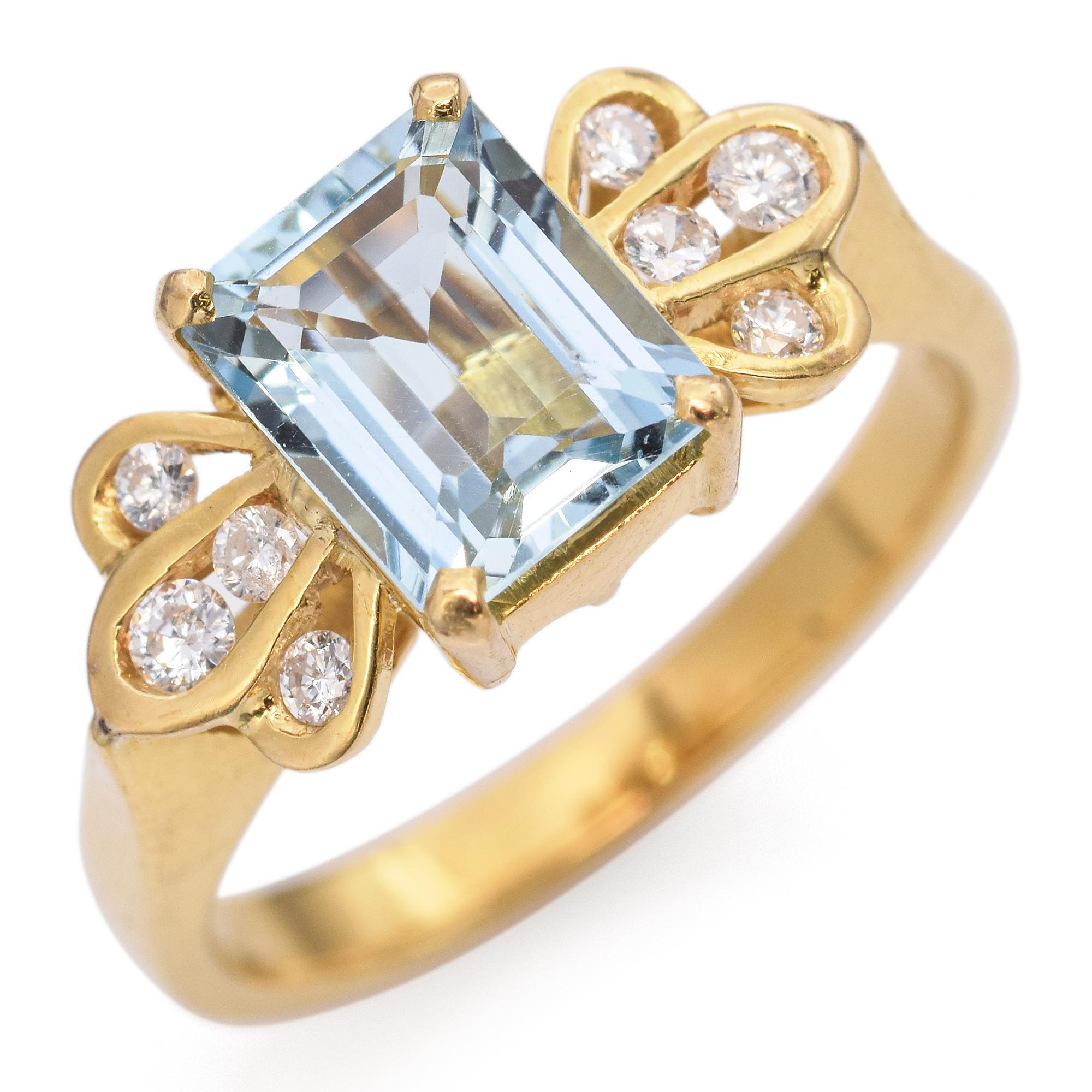 Aquamarine and diamond ring featuring an emerald-cut aquamarine flanked by two clusters of round brilliant-cut diamonds set in gold.

Weight: 3.7 grams 
Stone: Aquamarine 7mm by 5.7mm 
Measurements: 15.5mm by 7.8mm 
Ring Size: Size 4.5 
Hallmark: