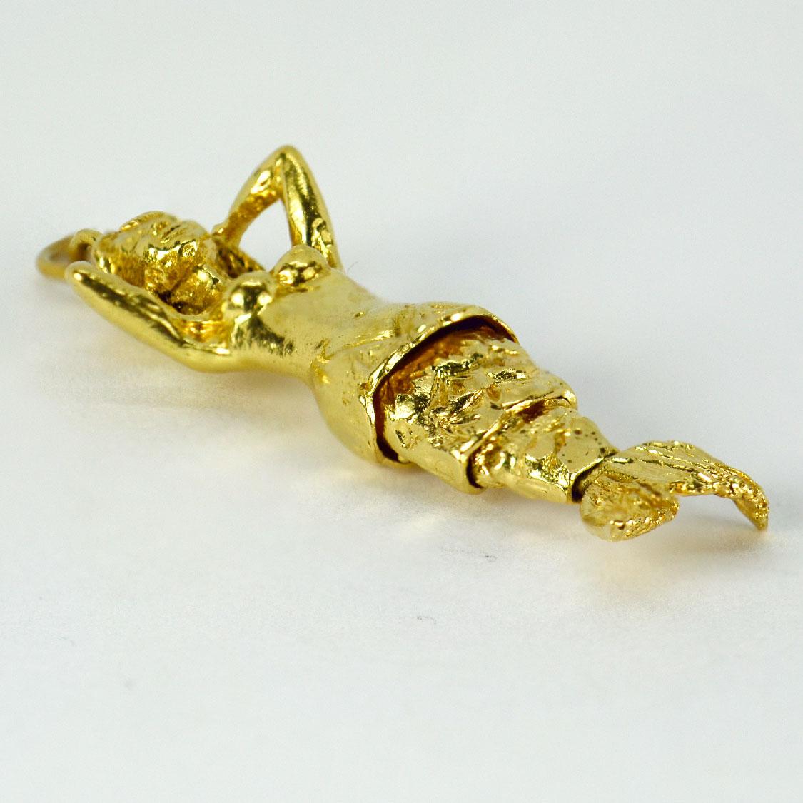 An 18 karat (18K) yellow gold charm pendant designed as a mermaid with an articulated flexible tail. Stamped 18ct  to the bail for 18 karat gold.

Dimensions: 4.8 x 1.7 x 0.8 cm (not including jump ring)
Weight: 12.00 grams 

