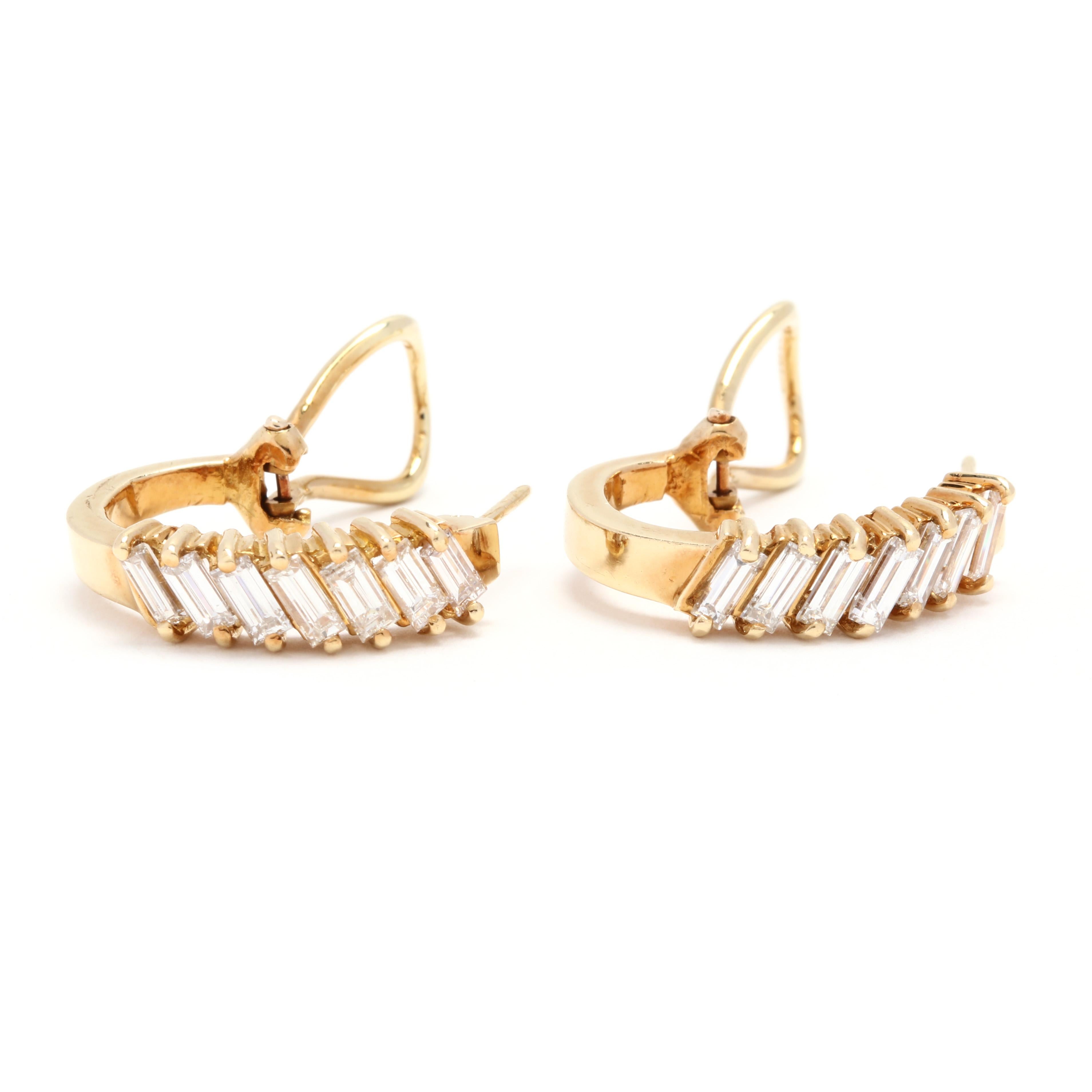 A pair of 18 karat yellow gold and baguette diamond hoop earrings. These earrings feature a J hoop design with prong set baguette cut diamonds set on an angle weighing approximately 1.84 total carats and with pierced Omega backs.

Stones:
-