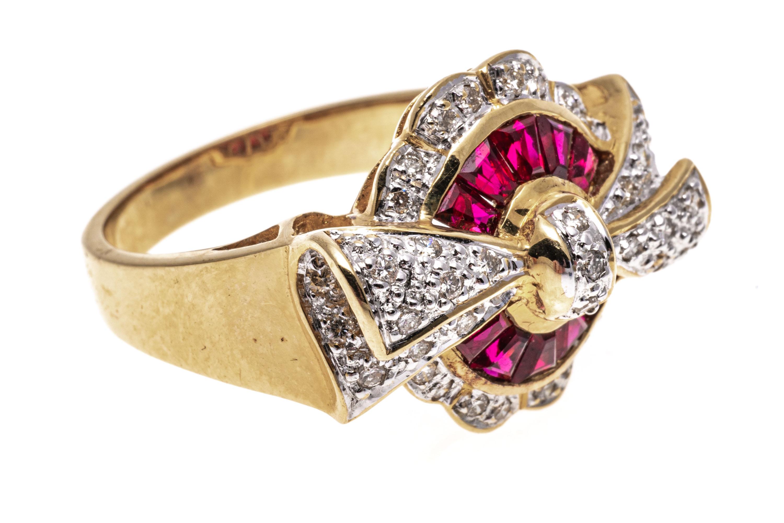 18k yellow gold ring. This striking yellow gold ring is a round shield motif, set with a center of tapered baguette cut rubies, channel set and framed with a scalloped border of round faceted diamonds, Set across the top is a bow motif, pave set