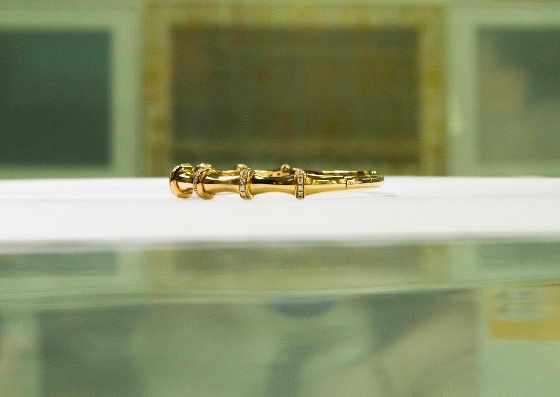 •	Metal: 18K Yellow Gold 
•	Weight: 13.54gm
•	Gemstones: Natural Diamonds
•	Total Diamond Weight: 0.76ct (64 stones)
•       Diameter of bracelet: 1.8 inch - 2.3 inch
A symbol of renewal and grace, this elegant yellow gold bangle is adorned with 64