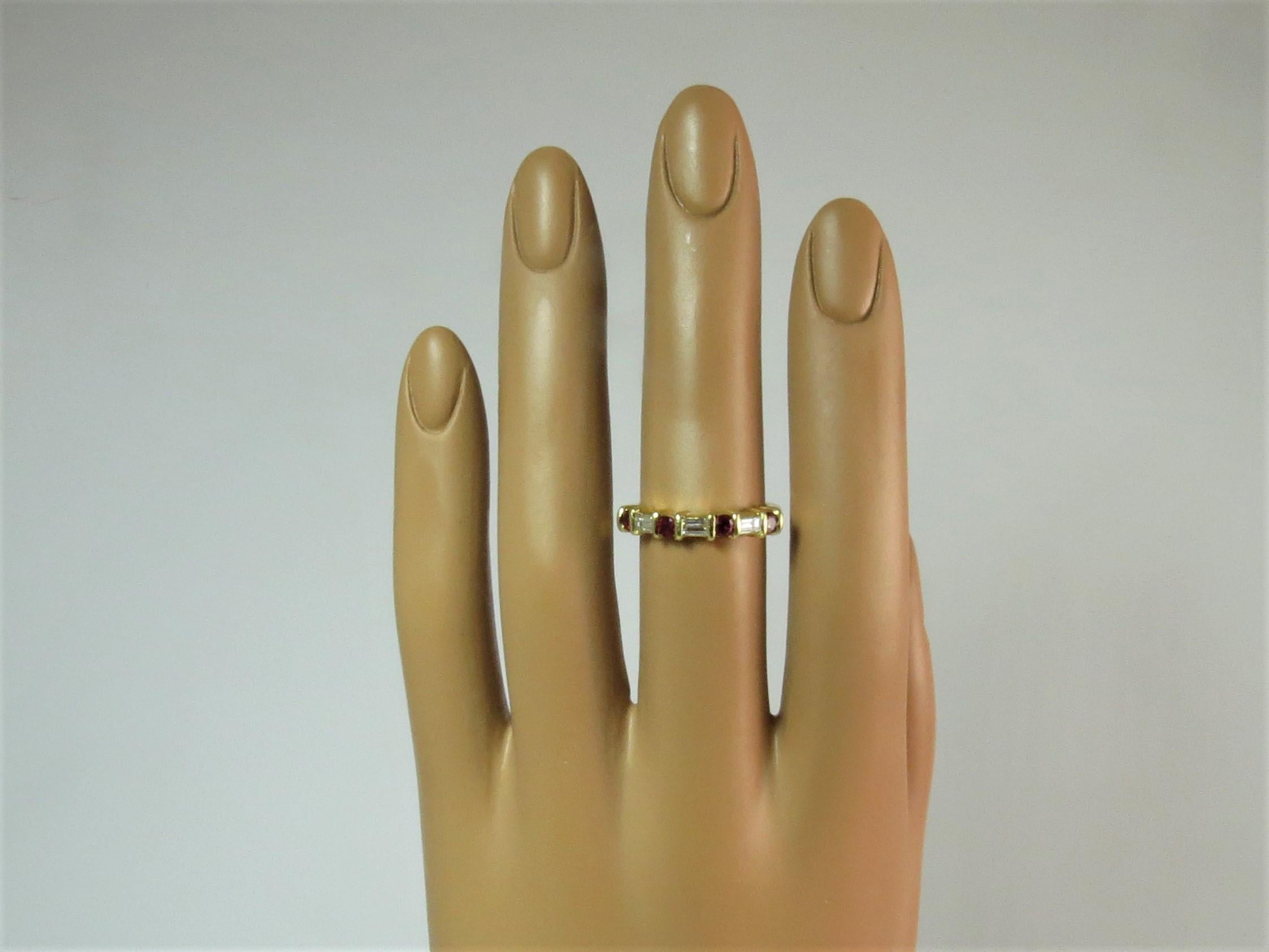 18K yellow gold band ring, with 4 round rubys weighing .52cts total and 3 baguette diamonds weighing .32 cts. 
Finger size 6.
May be sized.
Retail $2650