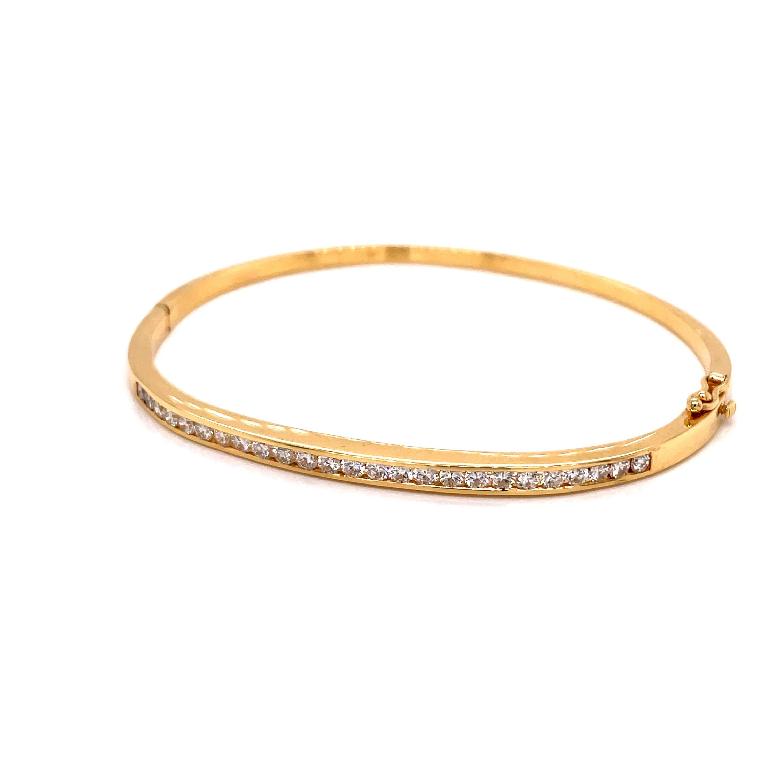 18K Yellow Gold Bangle Bracelet Channel Set Diamonds - The bangle contains 25 round brilliant diamonds weighing approximately 1.50ct. The diamonds are G-H color and VS clarity. The bangle measures 3.5mm wide on the top and 2.3mm wide on the bottom.