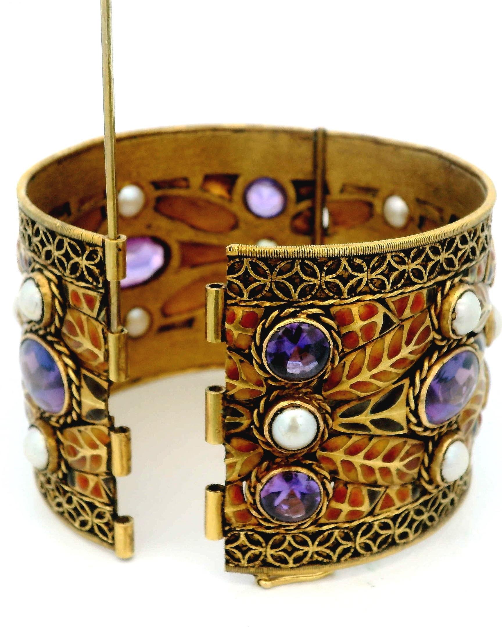 Esta impresionante pulsera es un ejemplo perfecto de artesanía fina. Presenta una hermosa combinación de vibrantes gemas amatistas y lustrosas perlas, elegantemente dispuestas sobre un fondo de rico oro. El diseño se enriquece aún más con