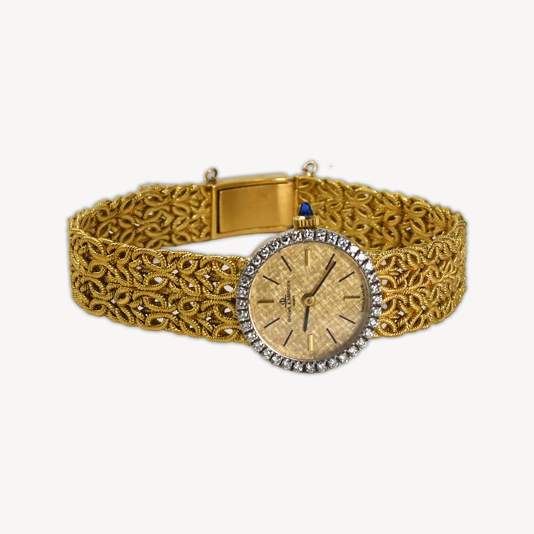 18k Yellow Gold Baume & Mercier Vintage watch with Diamond Bezel.
Was made circa 1970s.
Ornate woven bracelet with folding clasp.
Measures 7 in.
The watch runs and is in great condition.
No signs of any damage or heavy wear.
17 jewel manual wind