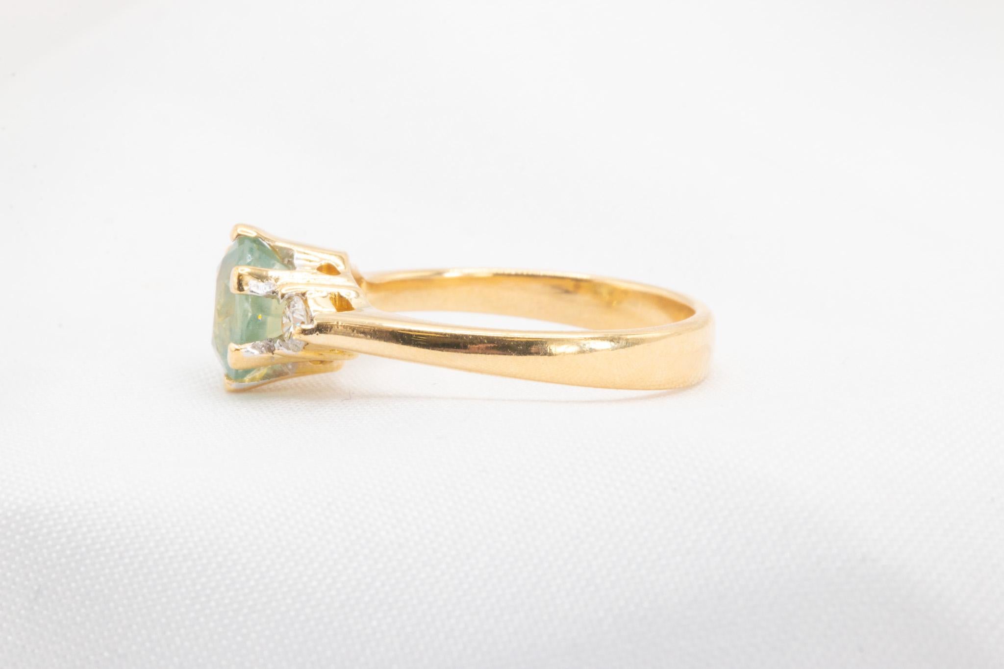 This stunning ring showcases an approximately 1.54-carat round bi-color sapphire, beautifully complemented by round-cut diamonds totaling approximately 0.12 carats (F-G color, VS clarity). Set in luxurious 18K yellow gold and weighing 3.3 grams,