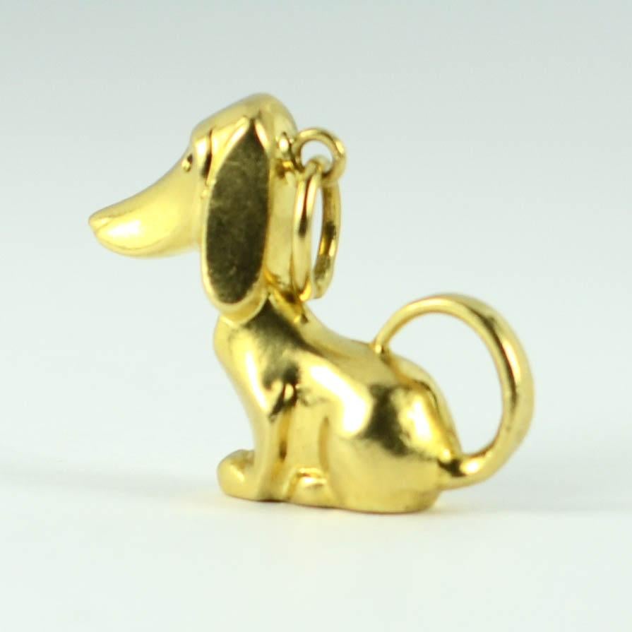 An 18 karat (18K) yellow gold charm pendant designed as a three-dimensional sitting dog with black enamel eyes. Unmarked but tested as 18 karat gold.

Dimensions: 2 x 2.3 x 0.7 cm (not including jump ring)
Weight: 2.18 grams