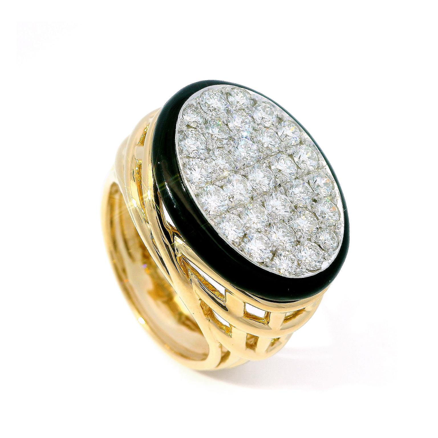 The center is an oval plane of brightness, courtesy of pave set round brilliant cut diamonds. Black enamel surrounds the jewels, its contrast making the diamonds seem still lighter. Underneath is an 18k yellow-gold four-piece split shank. Gold wires