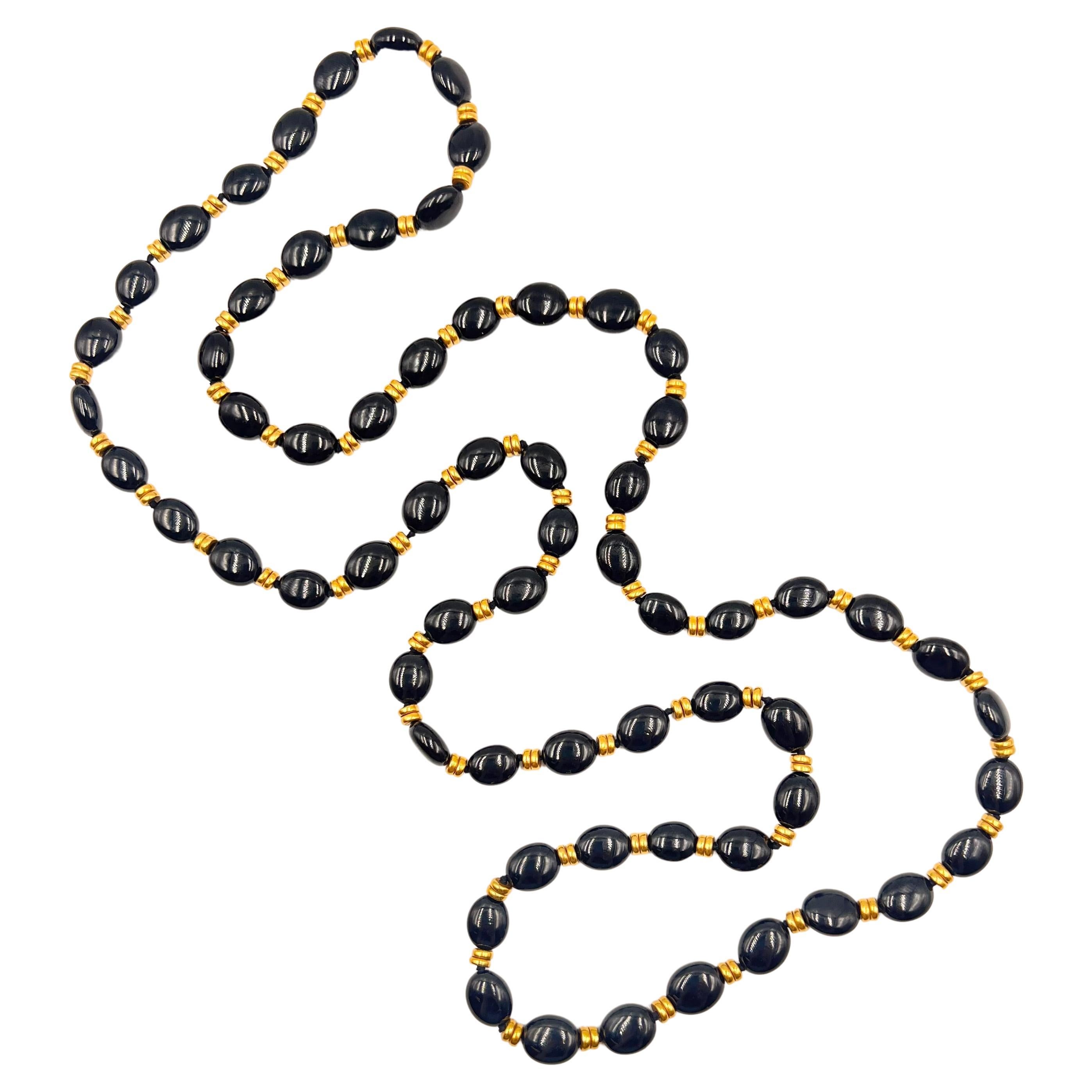 Long necklace, featuring a single-strand of sixty-five oval black onyx polished beads with double rings of 18kt yellow gold rondelle-style beads set in between each.  Measuring 37