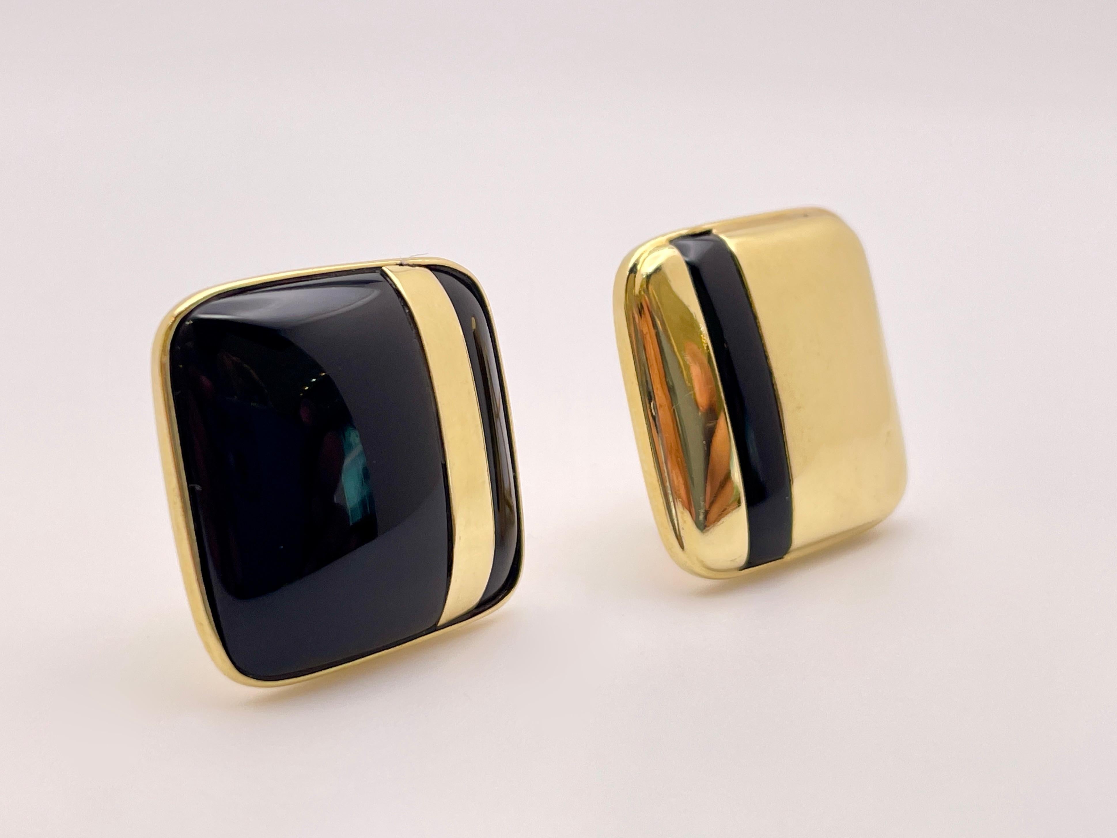 An original pair of 18K yellow gold black onyx square earrings. These beautiful earrings mirror each other in design, with one contrasting a black onyx surface with an 18K yellow gold strip while the other contrasts an 18k yellow gold surface with