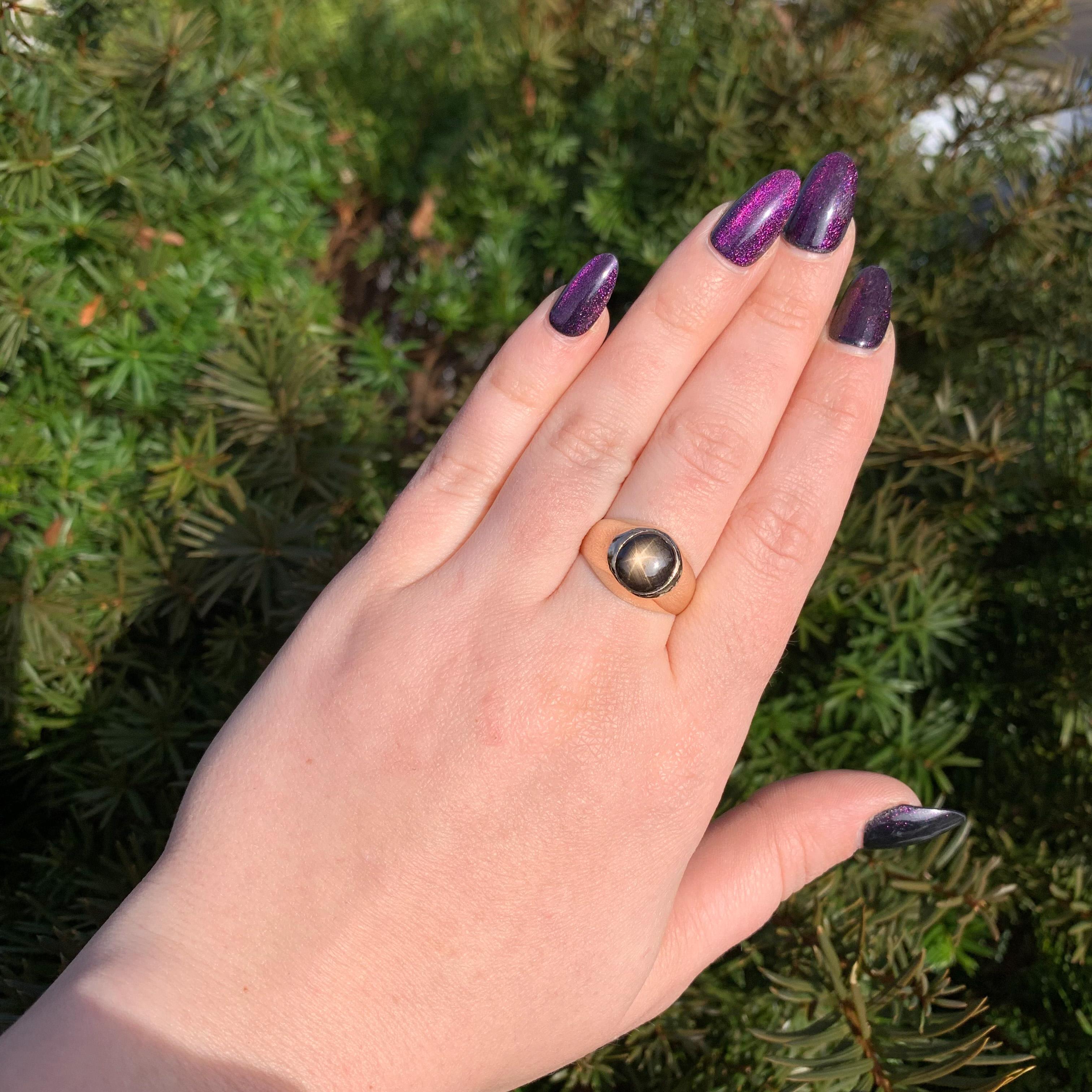 Vintage 18K yellow gold men's ring featuring an oval black star sapphire. The dark brown/black sapphire has a 6 rayed star and measures about 10mm x 8mm. The ring fits a size 9 finger, weighs 5.44dwt and dates from the 1950-60's.