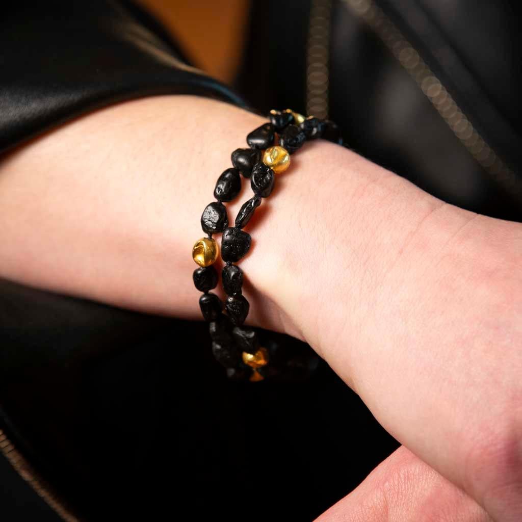 Embrace elemental elegance with this striking double-strand bracelet by celebrated designer Jorge Adeler. Handcrafted in 18k yellow gold, the piece features raw black tourmaline beads—revered for their grounding energy—paired with organically shaped