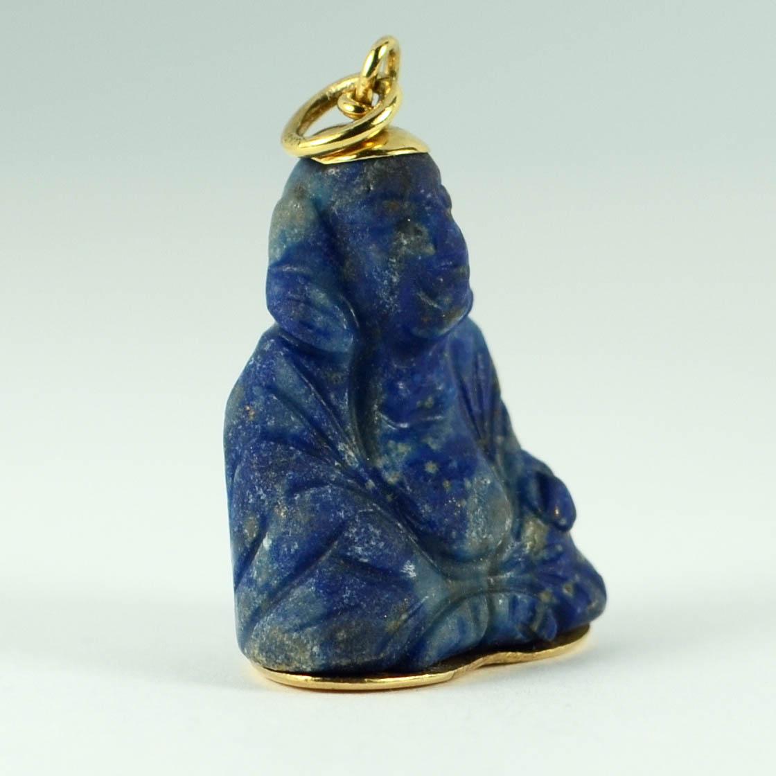 A charm pendant designed as a large carved Buddha sculpture in blue lapis lazuli with 18 karat (18K) yellow gold terminals. Marked 750 to the jump ring for 18 karat gold.

Measurements: 3.1 x 2.2 x 1.5 cm (not including jump ring)
Weight: 10.82 grams
