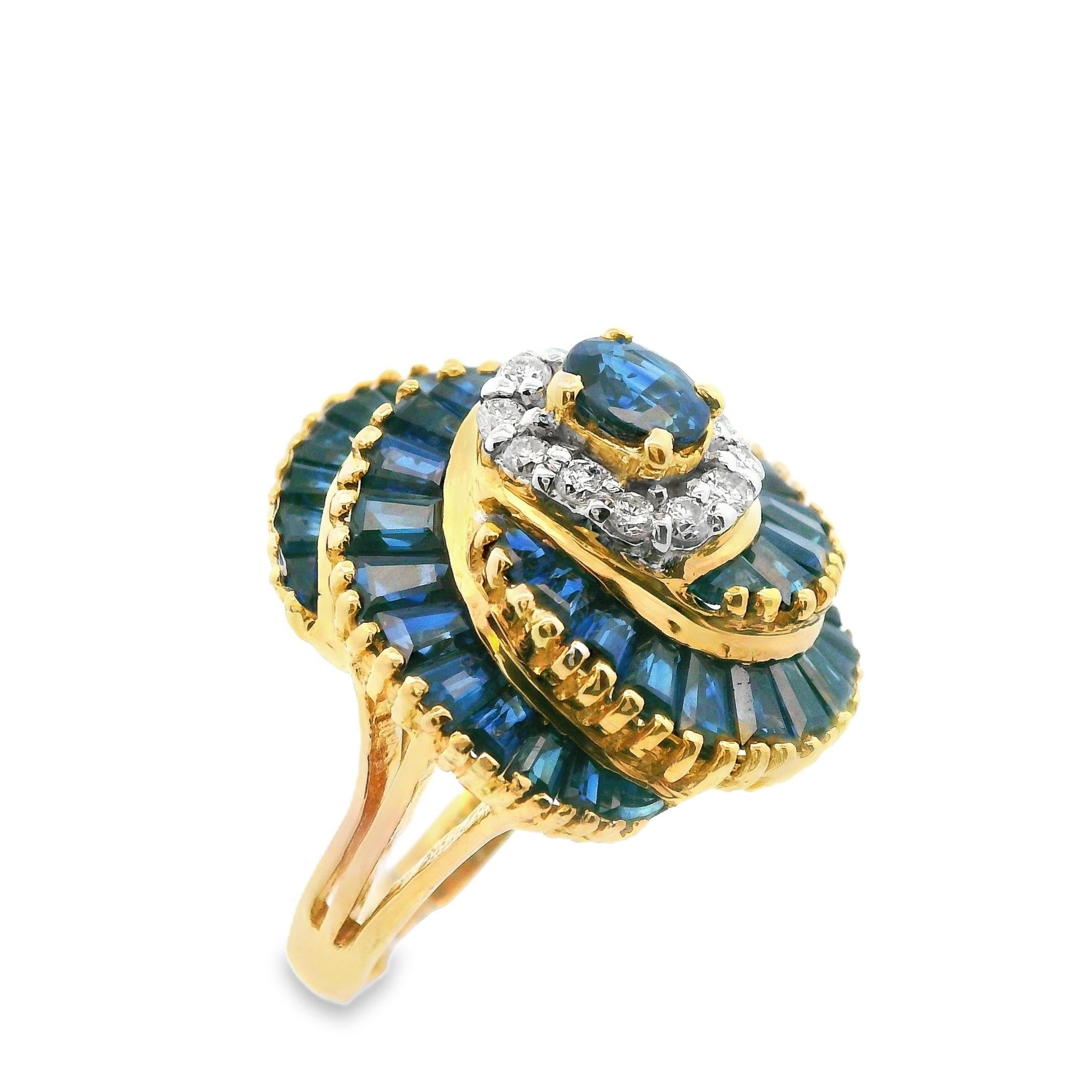 This pretty ring is made in 14k yellow gold with natural rich blue sapphires and sparkly diamonds. The center of the ring is a traditional halo styled design that features a large oval cut sapphire in the center that is surrounded by a halo of