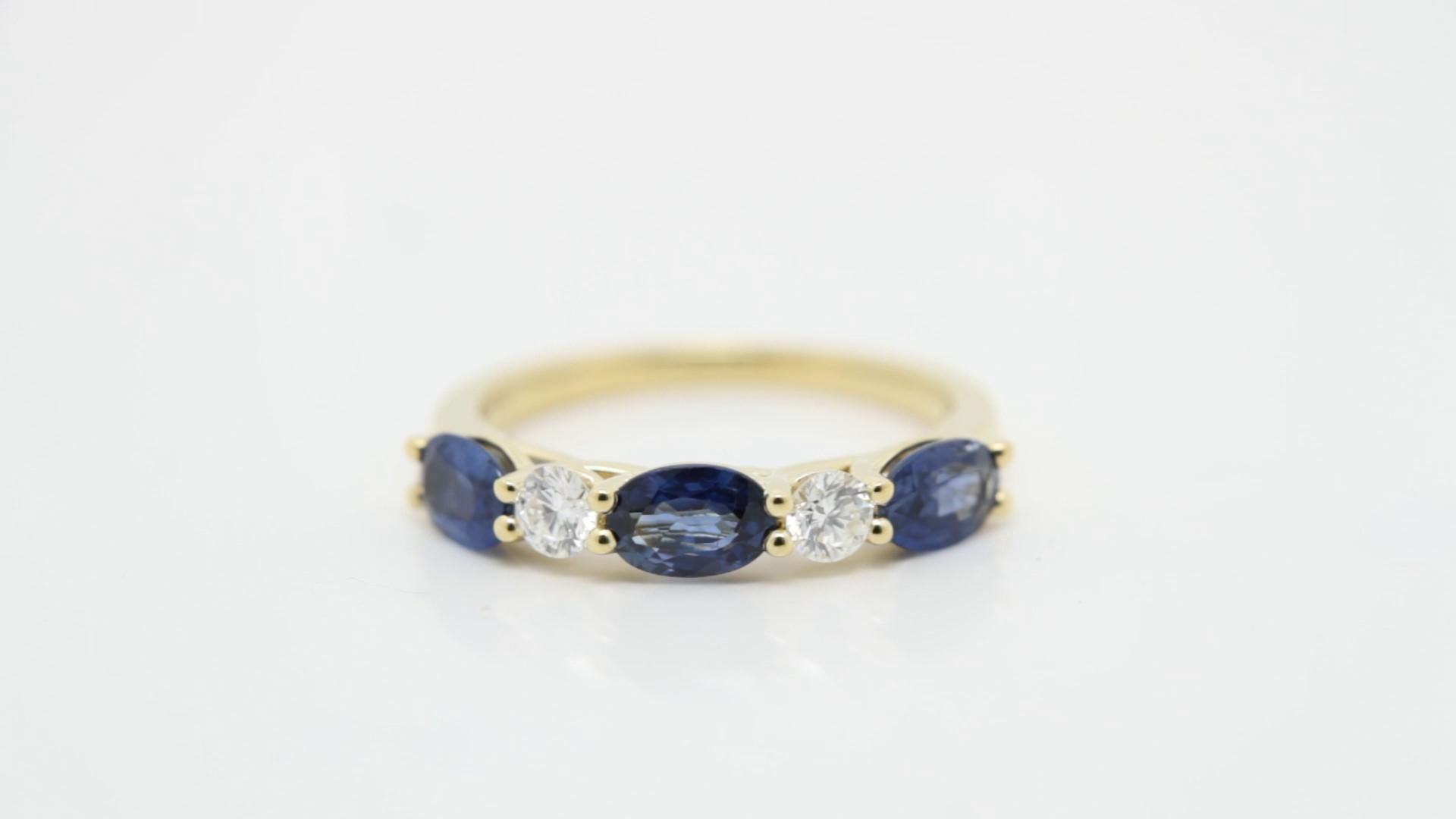 Cette bague rayonnante est réalisée en or jaune 18 carats lumineux et est centrée sur un saphir bleu de 6×4 mm d'une teinte riche et veloutée. 

Flanquée de diamants blancs brillants, la juxtaposition du saphir profond et des diamants étincelants