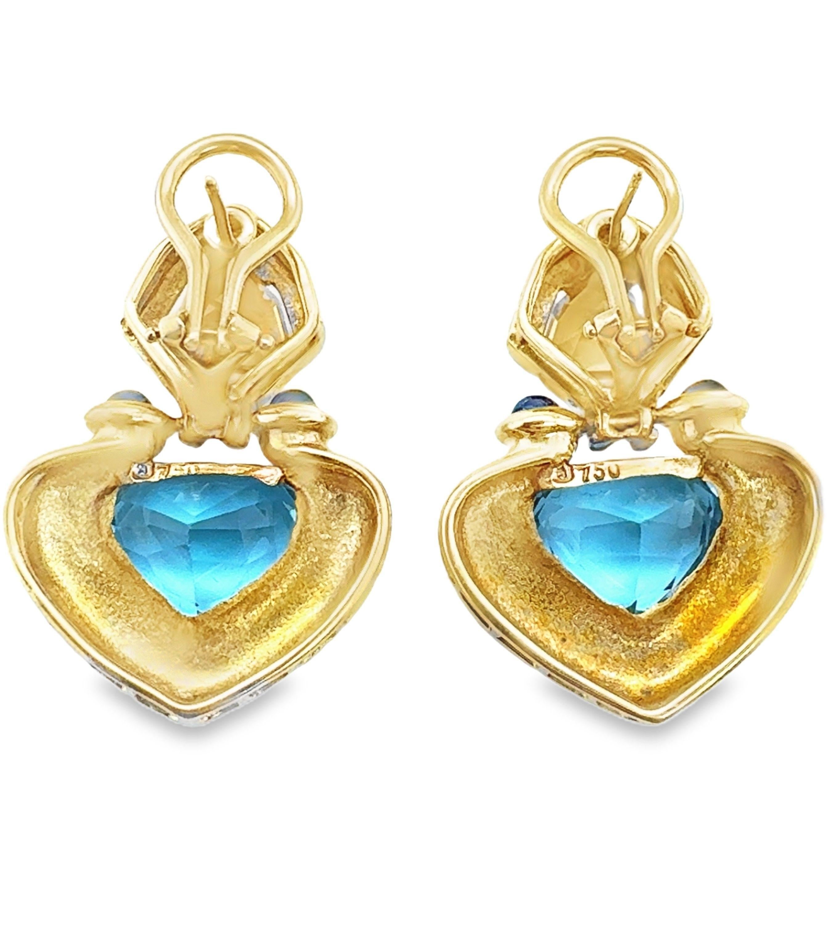 This eye-catching pair of 18K yellow gold earrings features a playful yet elegant mix of gemstones in a charming heart shape, embodying the bold and colorful style of the 1970s. Each earring showcases a radiant heart-shaped blue topaz totaling 6