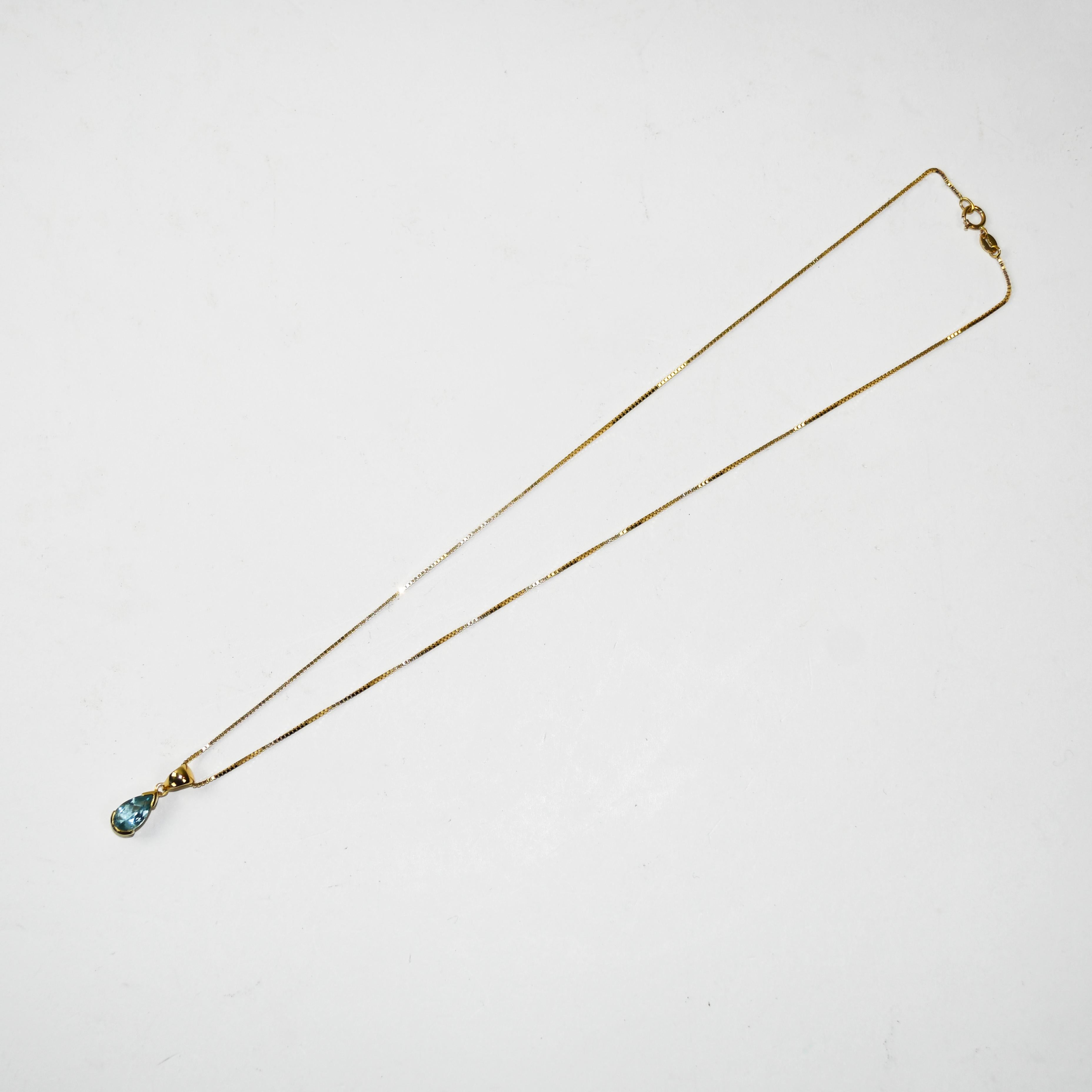18k yellow gold and blue topaz pendant necklace.
Stamped 750 and weighs 4.5 grams gross weight.
The blue topaz is a pear shape, 1.50 carats.
The chain is a 1mm thick box link, measuring 17 inches long. 
Overall, excellent condition.