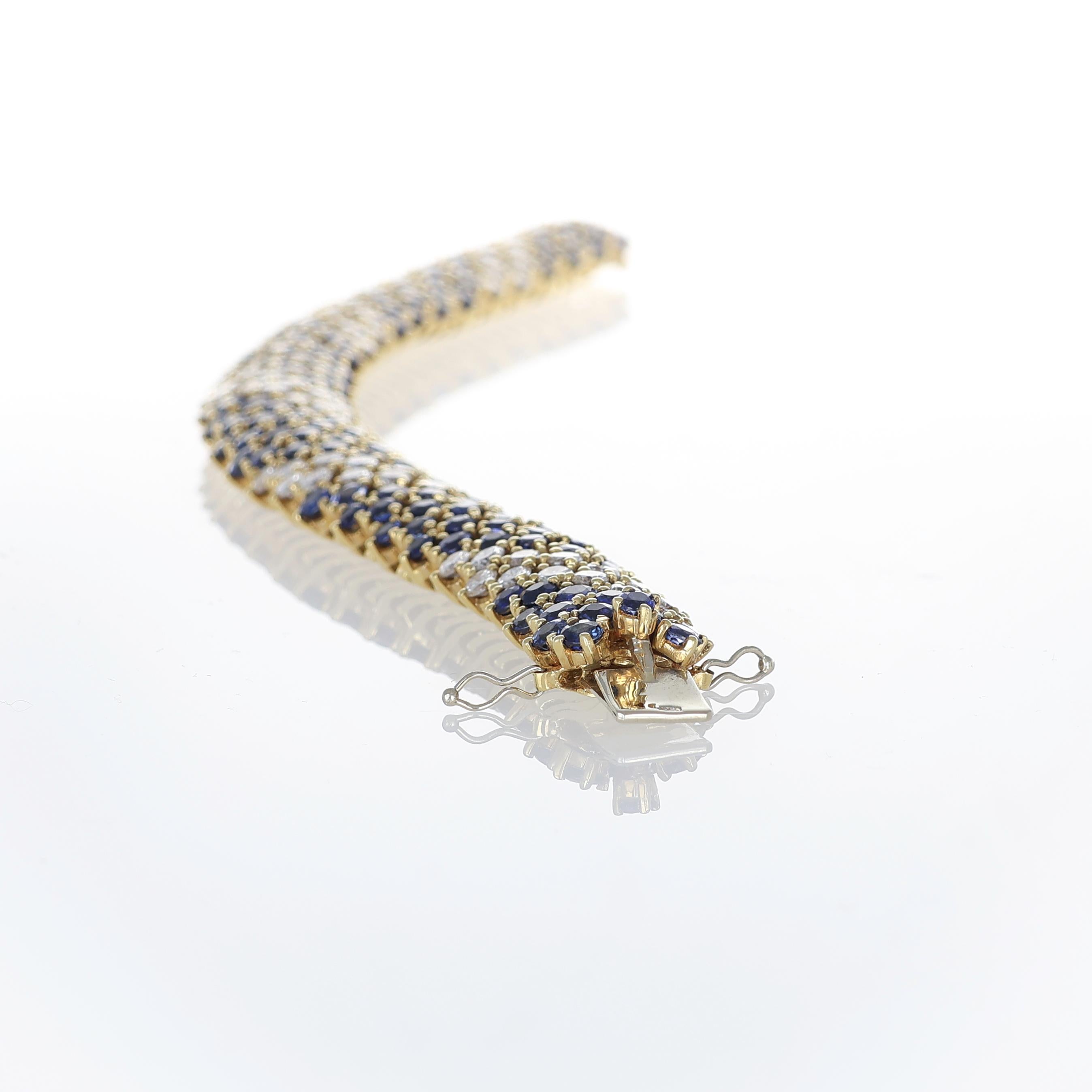 A bold and refined masterpiece, this 18K yellow gold bracelet features a lavish pavé of blue sapphires and diamonds in a striking, seamless design. The deep blue sapphires, totaling 28.00 carats, form a mesmerizing contrast against the brilliance of