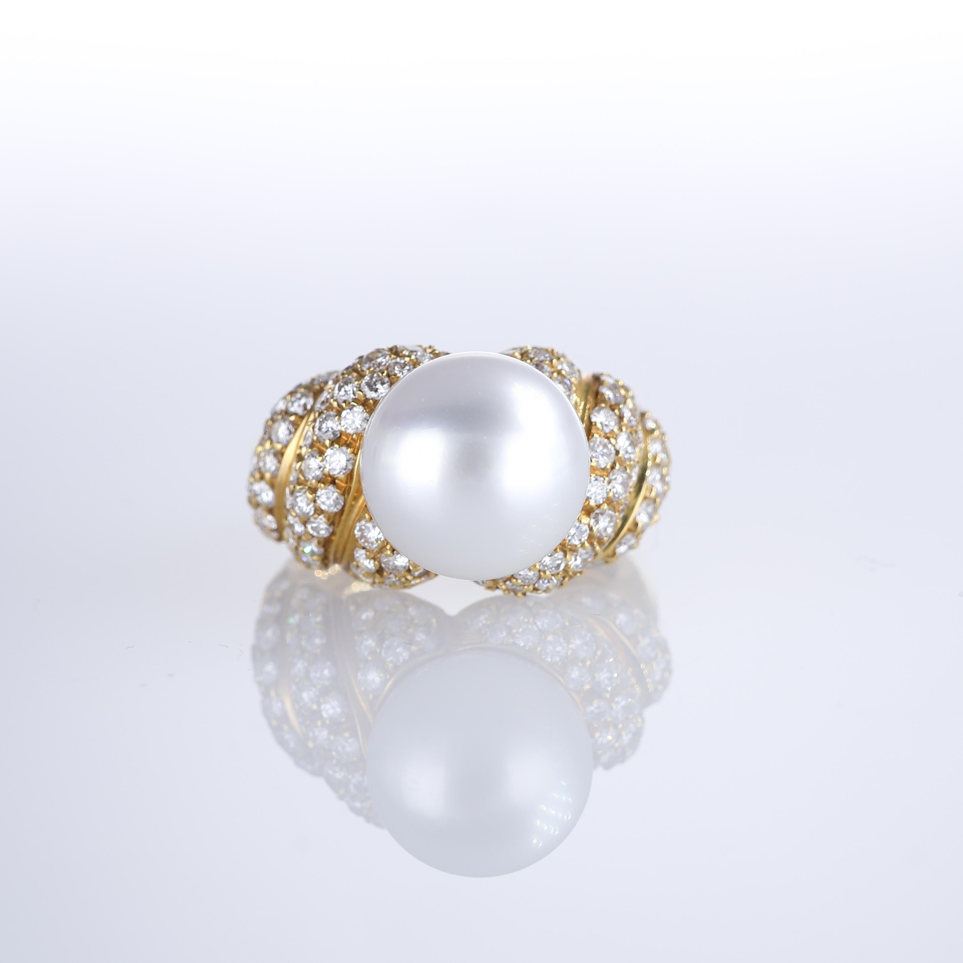 A striking 18K yellow gold ring featuring a luminous 10mm white pearl, framed by an intricate braided design adorned with pavé-set brilliant-cut diamonds. The interplay of textures and sparkle enhances the elegance of this statement piece, combining
