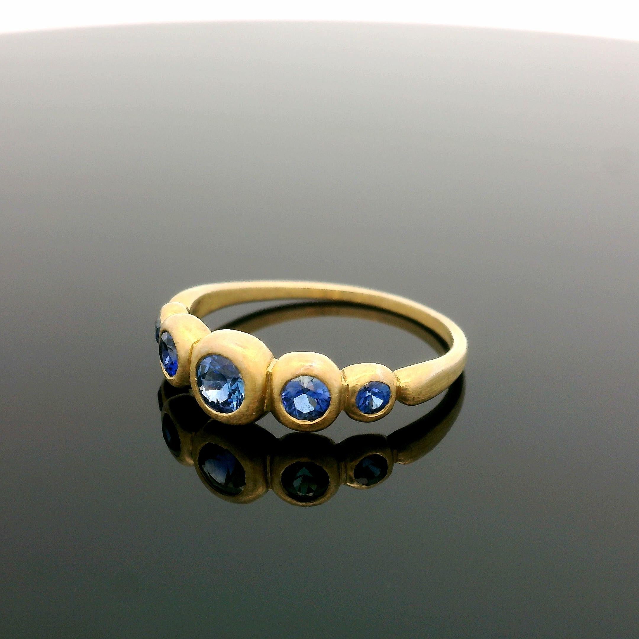Round Cut 18k Yellow Gold Brilliant Blue .75ctw Sapphire Bezel Graduated Pyramid Band Ring For Sale