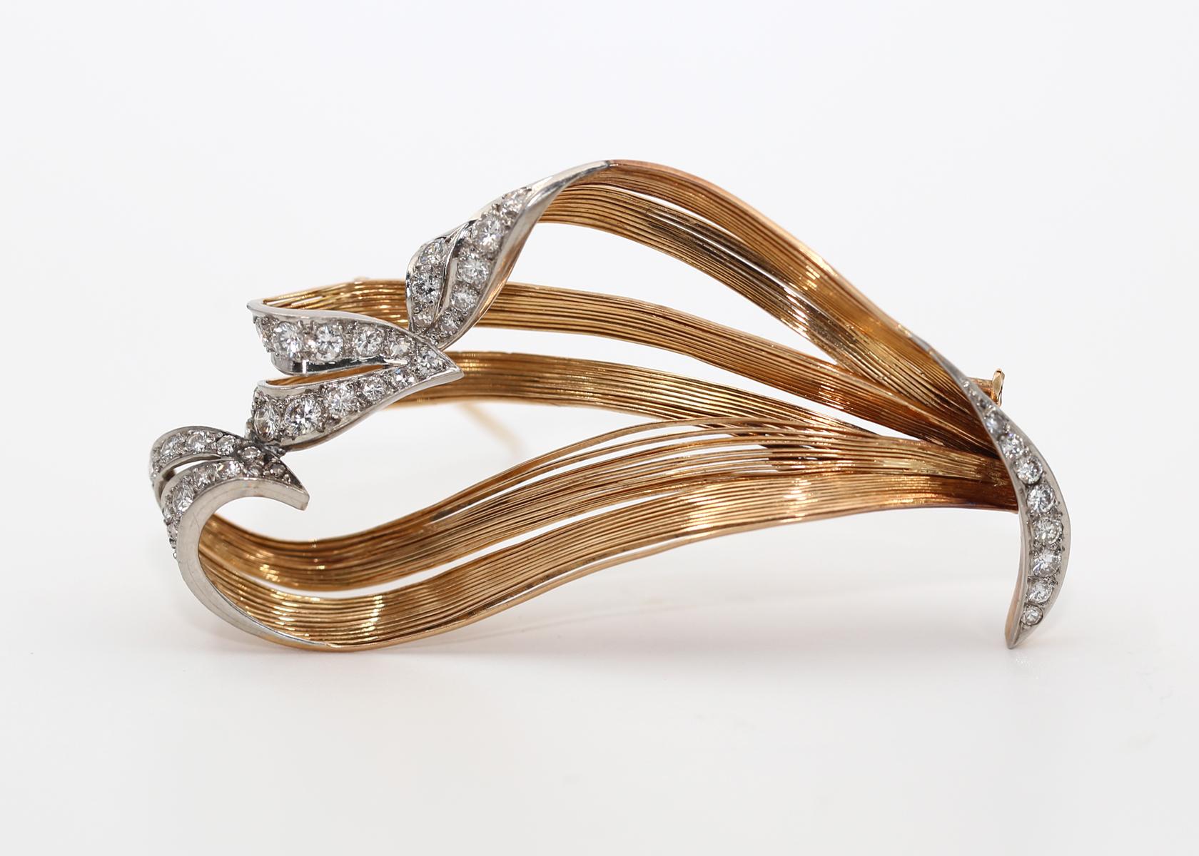 Broche en or jaune 18K Diamants Motifs naturels.
Il est composé de fils d'or et de décorations en platine, serties de diamants.

Créée vers 1930, elle se situe à une époque entre deux styles de design, dépassant l'Art déco et devant trouver quelque