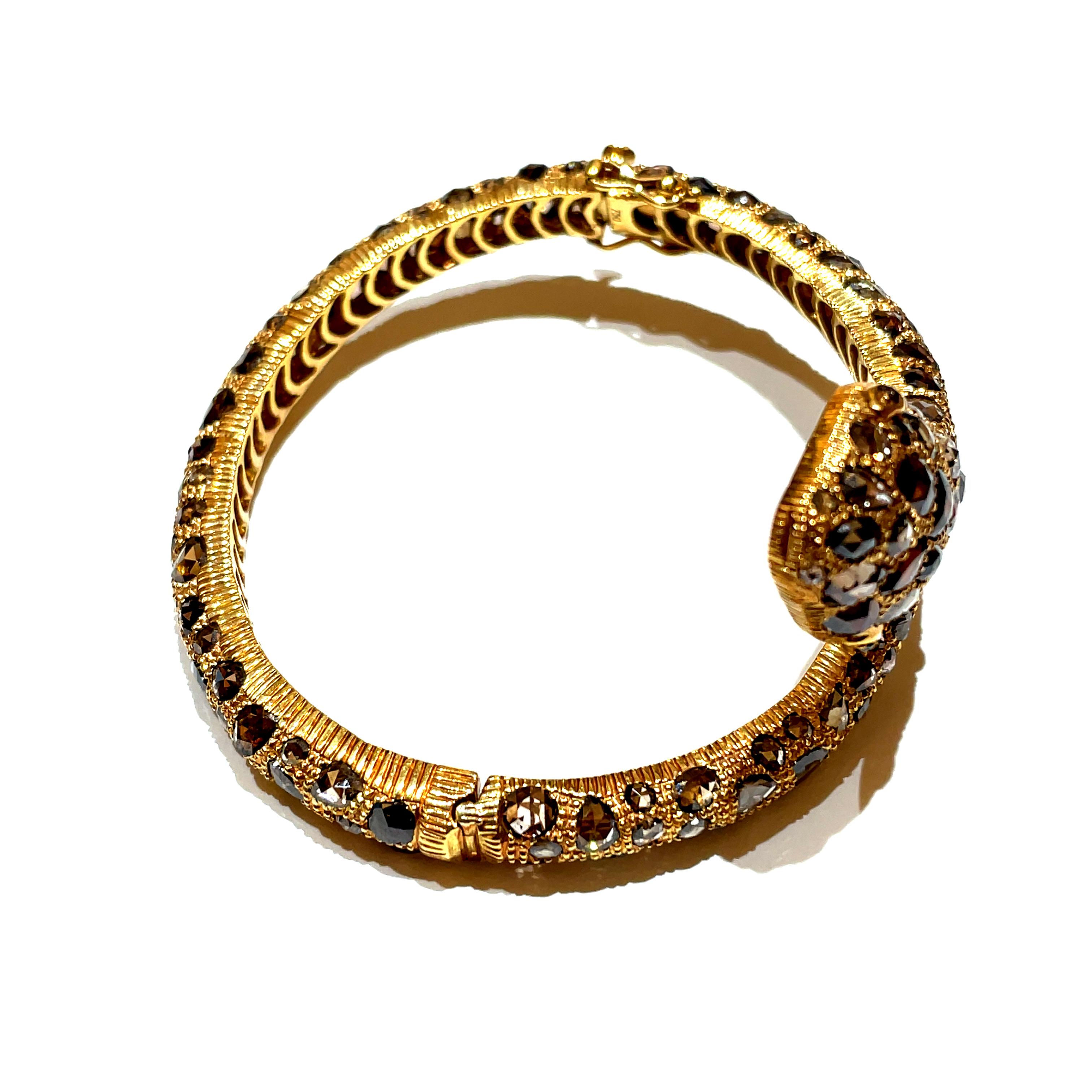 Wrapped around your wrist, the 18k Yellow Gold Glam Snake Bangle unfurls a tale of opulence and allure. 

Its intricate design, embellished with 158 Brown Diamond Rose Cuts totaling 18.46 carats, creates a striking semblance to the mesmerizing