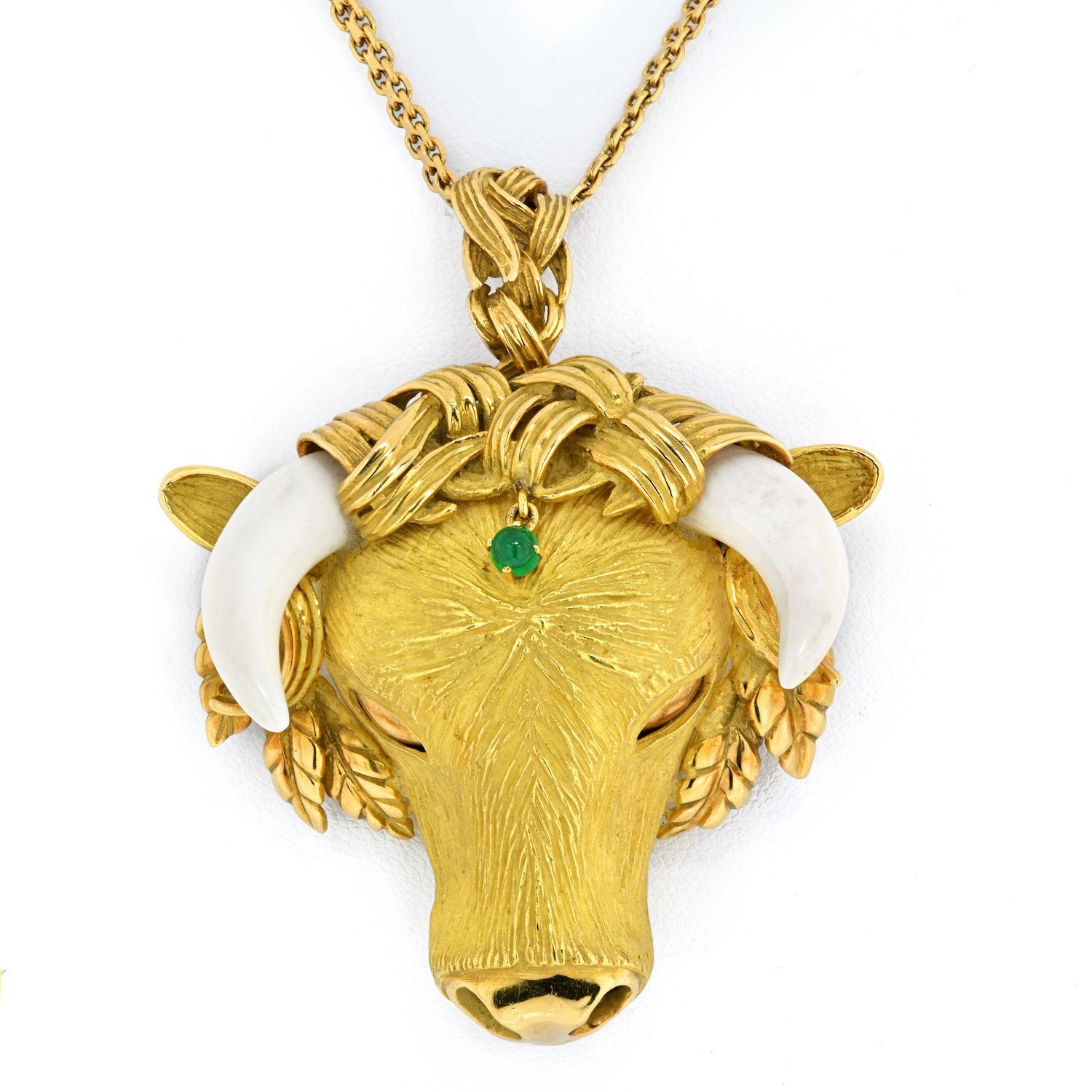 Very exquisite Bull pendant that converts into a brooch is designed in 18 karat yellow gold. The estate piece has natural ivory horns and emerald dangle from headdress. It is enhanced by beautiful polished leaves, polished nose and eyes. 

The head