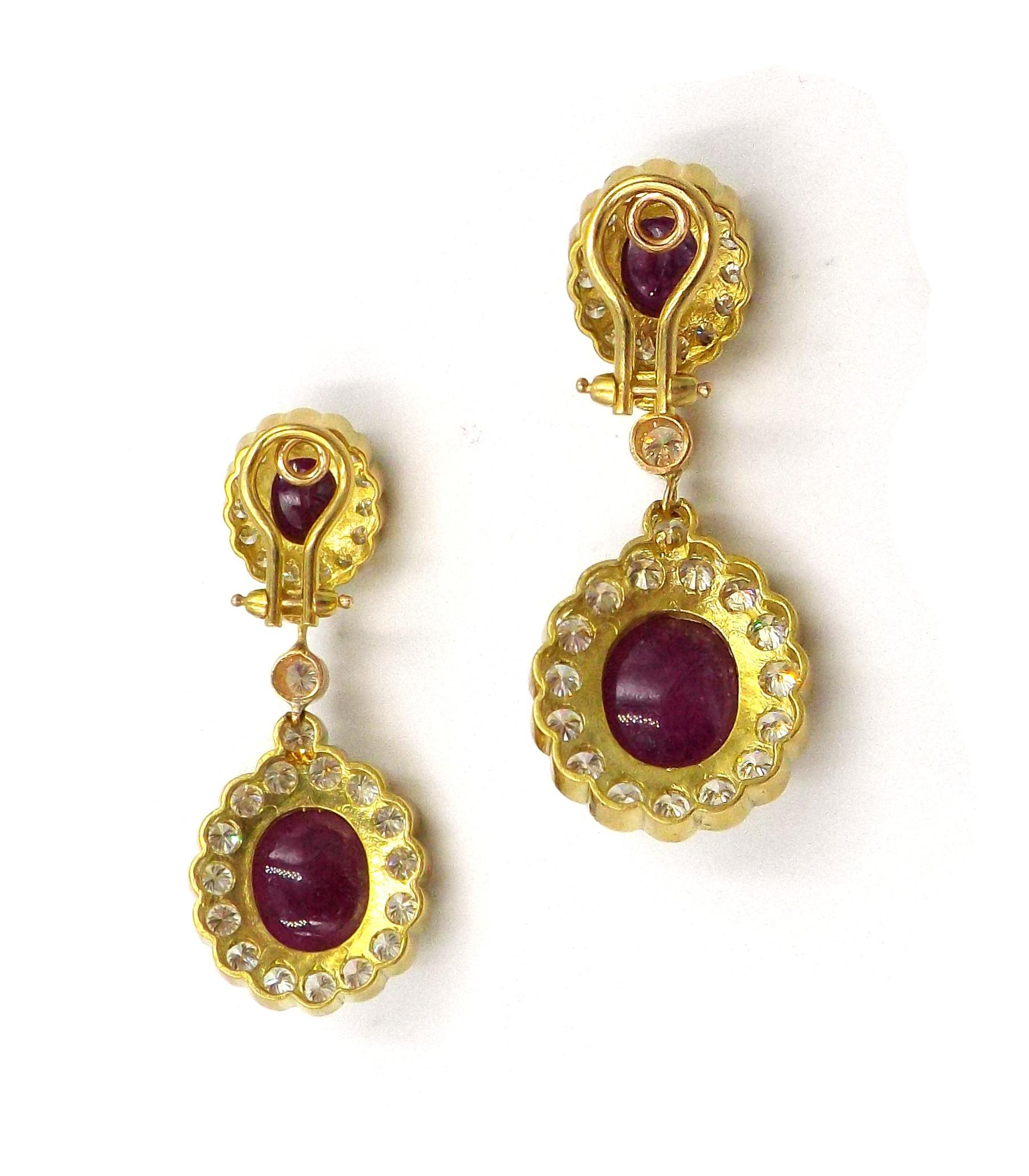 Each designed as an oval cabochon ruby with round diamond surround, suspending a larger pendant of matching design, mounted in 18k yellow gold. 66 round diamonds weighing a total of approximately 7.00 carats. Dimensions 4.9 x 2 cm (at widest point),