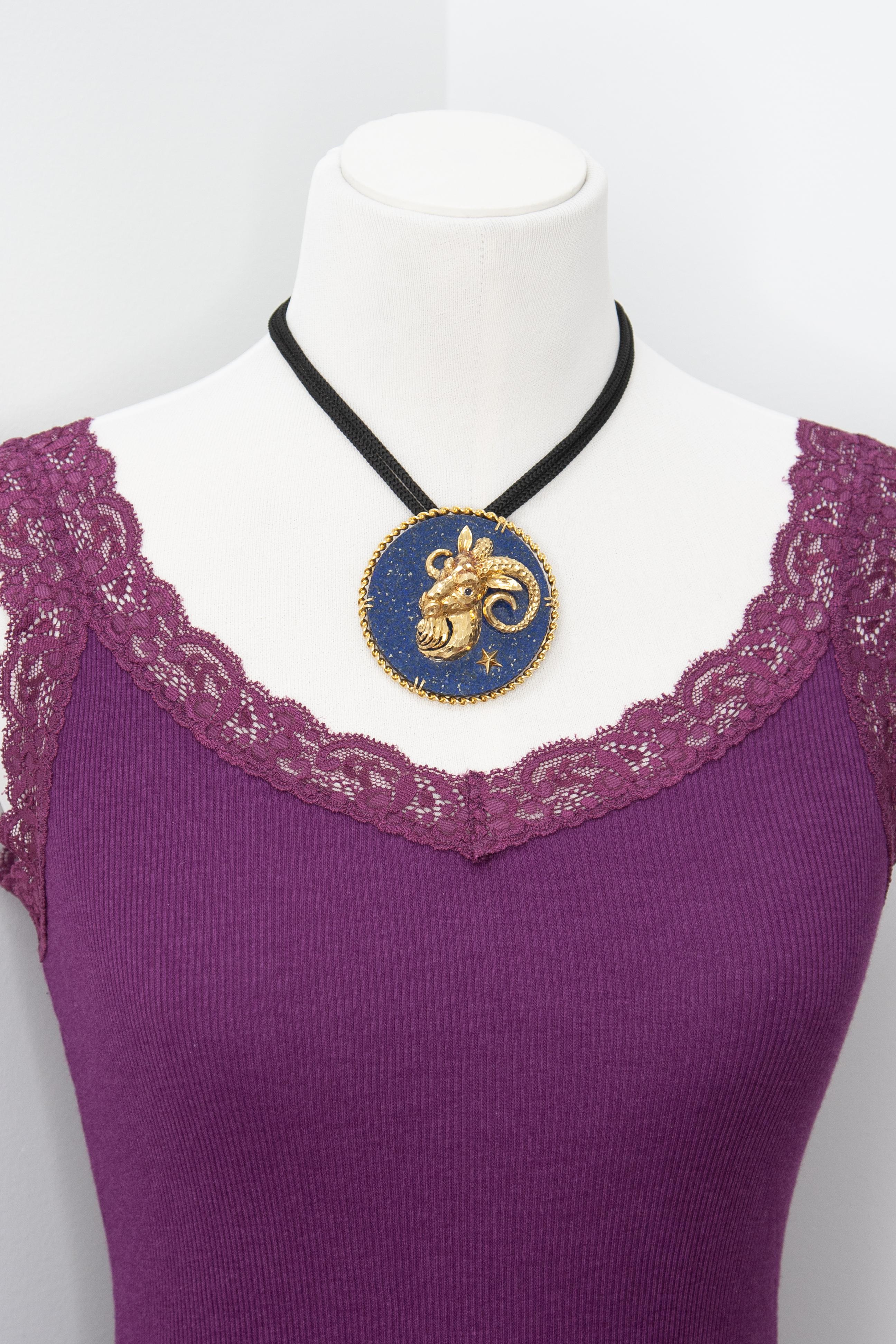 Este es un raro y coleccionable broche del zodiaco de Capricornio de oro de 18 quilates, con una cabeza de cabra tridimensional de rica textura y cuernos rizados, montada sobre un disco de lapislázuli azul oscuro con detalles de estrellas doradas.