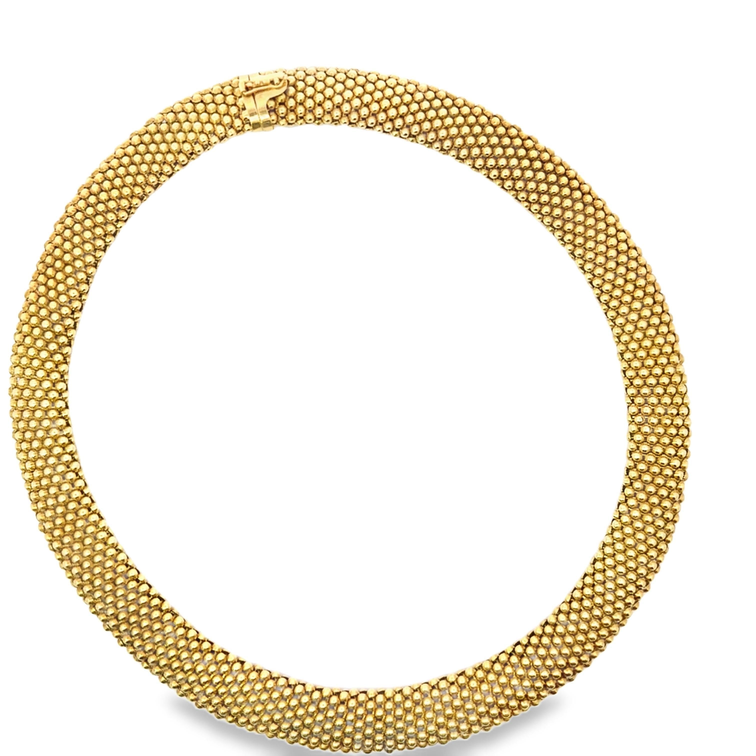 Diese elegante Halskette aus 18 Karat Gelbgold besticht durch ihr raffiniertes Design. Das Stück besteht aus sorgfältig angeordneten Goldperlen, die ihm ein strukturiertes und luxuriöses Aussehen verleihen.

Die nahtlose Form der Halskette ist kühn