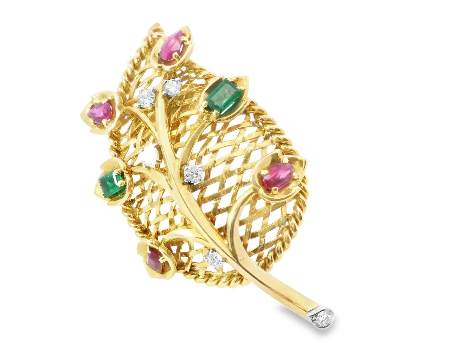 This exquisite Cartier brooch is a timeless representation of elegance and artistry. Handcrafted in France in 1940, the piece features a delicate leaf design adorned with vibrant green emeralds and rich red rubies. The harmonious contrast of the