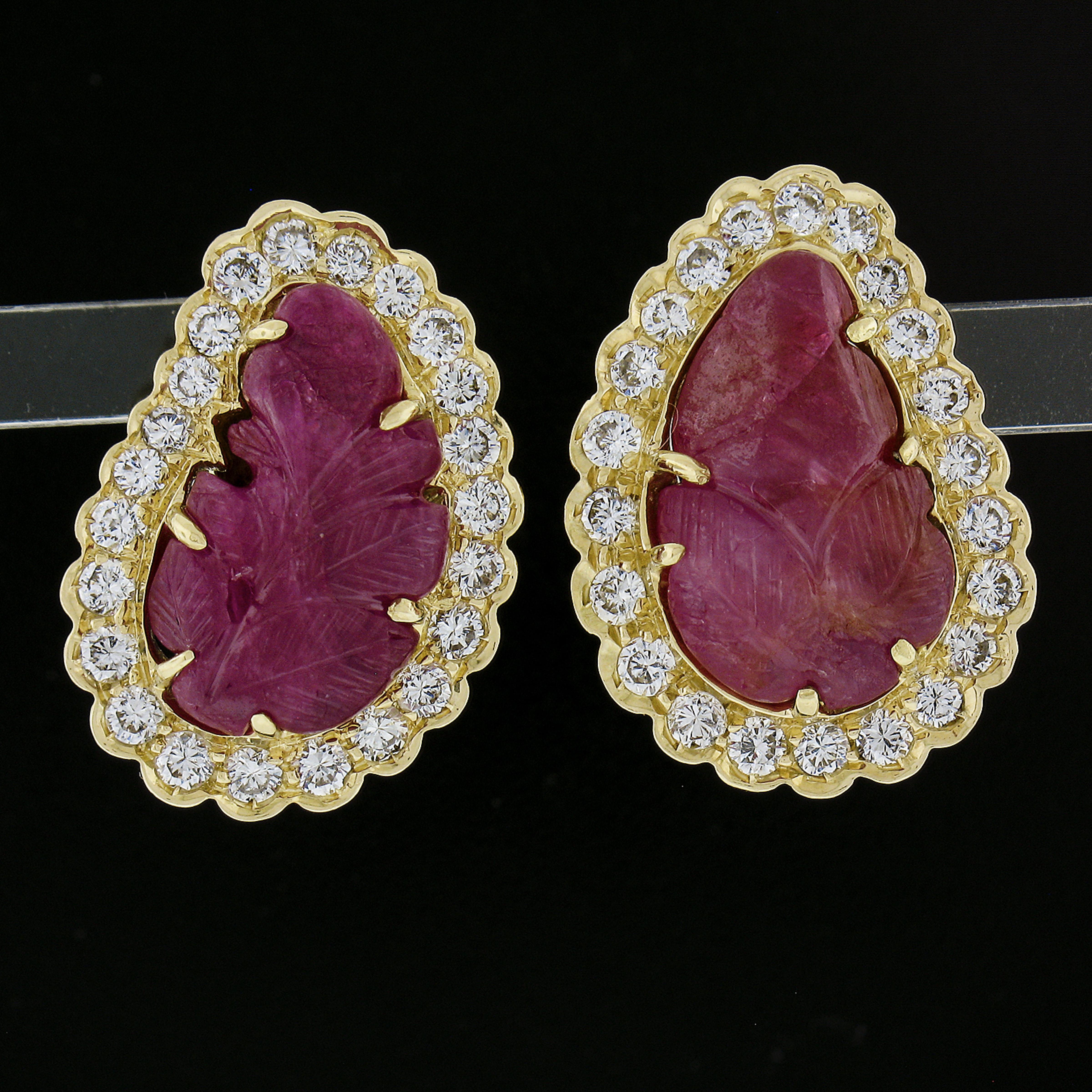 --Stone(s):--
(2) Natural Genuine Rubies - Carved Leaf Shape - Prong Set - Purplish-Red Color w/ Natural Inclusion and some surface Reaching - 15.9x9.3mm each (approx.)
(45) Natural Genuine Diamonds - Round Brilliant Cut - Pave Set - G-I Color -