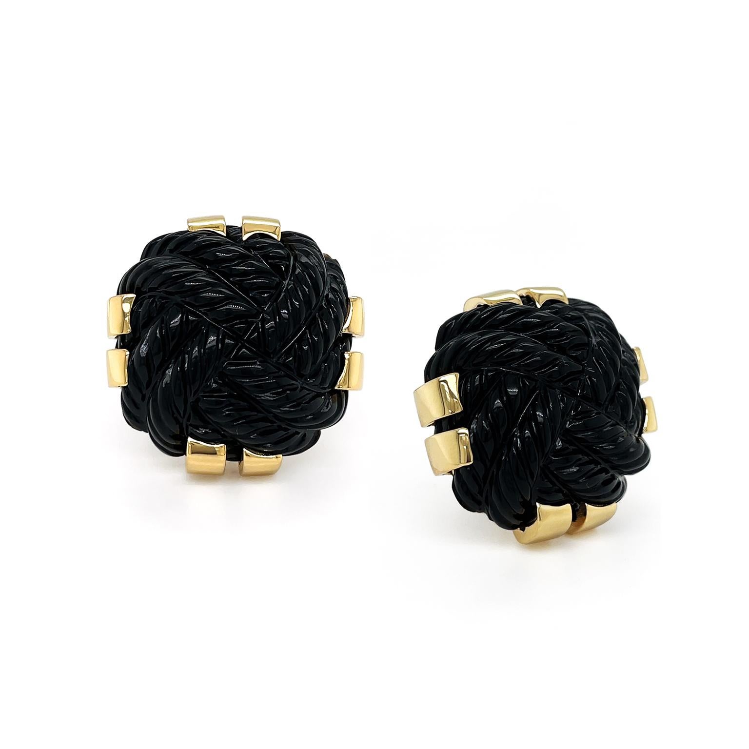 The elegant opacity of black onyx with a polished 18k yellow gold accent presents a sumptuous design for these earrings. Formed in a square shape, the gemstone features a carved braided pattern in a whorl for texture. 18k yellow gold double prongs
