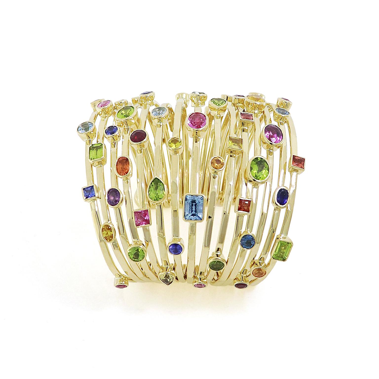Les couleurs et les sons animent ce bracelet Cha Cha. Le corps comporte quinze manchettes en or jaune 18 carats reliées entre elles à leurs extrémités par des barrettes. La barre relie les pièces tout en leur permettant de se déplacer et de glisser,