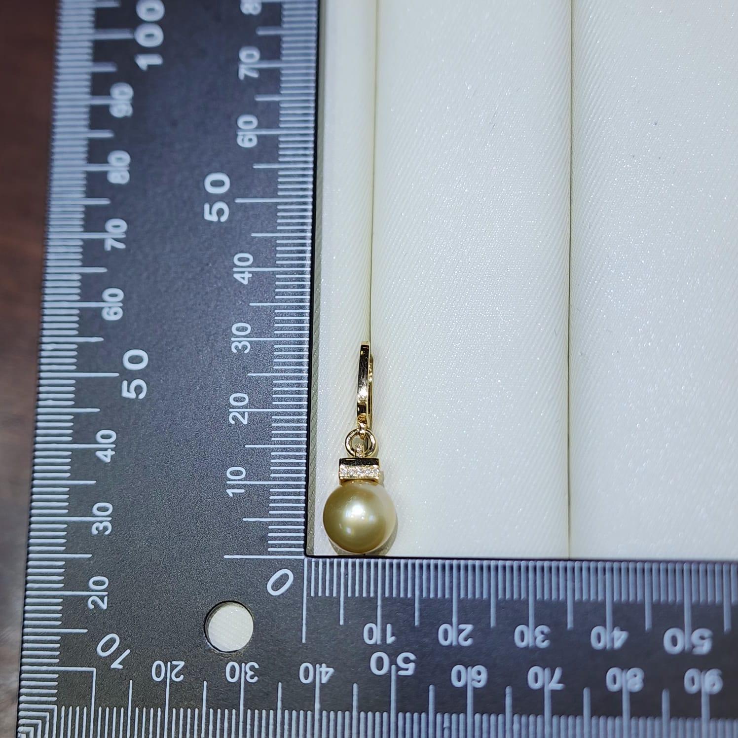 Questi eleganti orecchini sono caratterizzati da luminose perle dei mari del sud da 10 mm in una calda tonalità champagne, ciascuna sospesa da un cerchio lucido in oro giallo da 18 carati. La tonalità naturalmente ricca delle perle è completata da