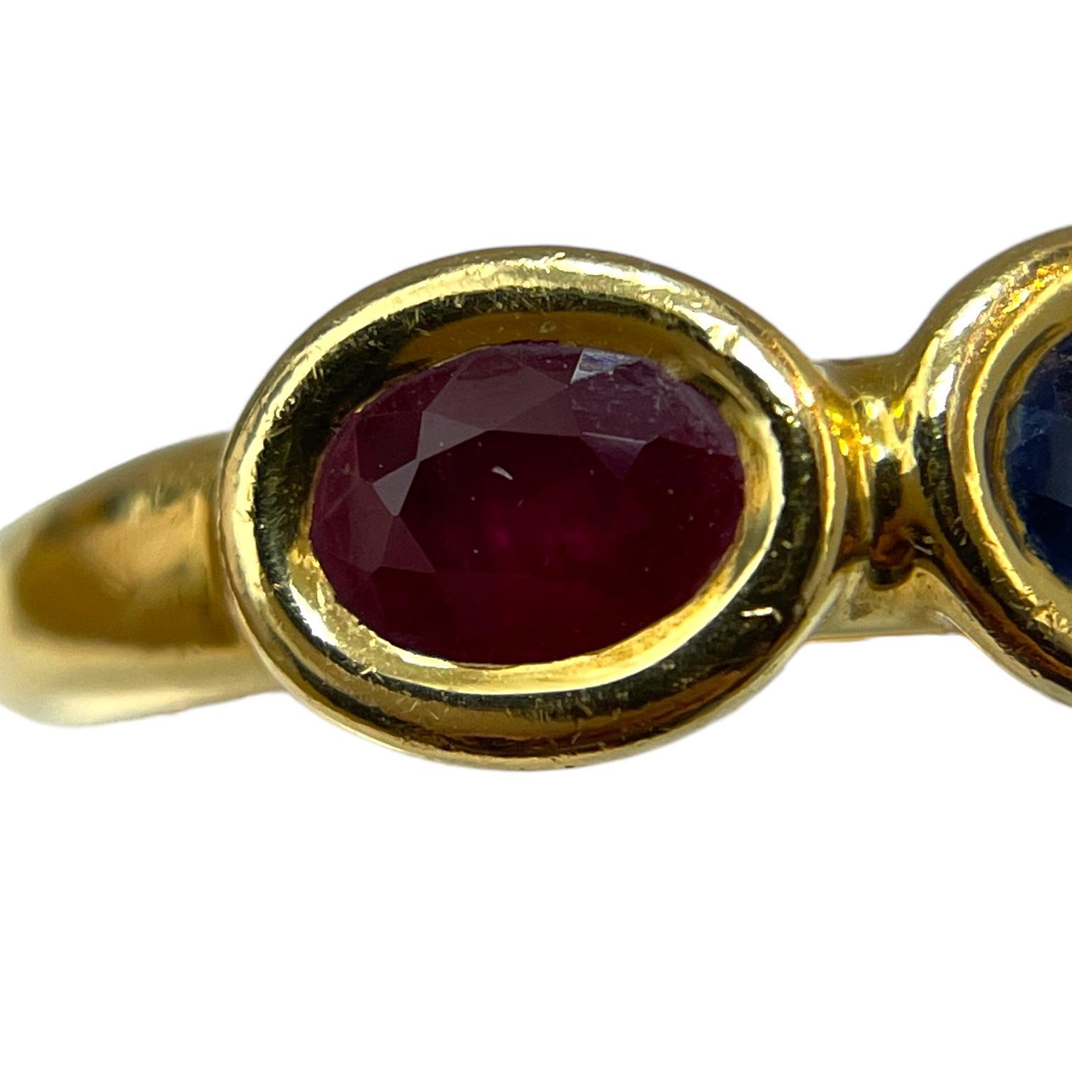 Discover the elegance of this 18K Yellow Gold Chaumet Paris Ring, featuring exquisite oval-cut ruby and sapphire gemstones. The rich red ruby and deep blue sapphire are beautifully set in a luxurious yellow gold band, showcasing Chaumet's timeless