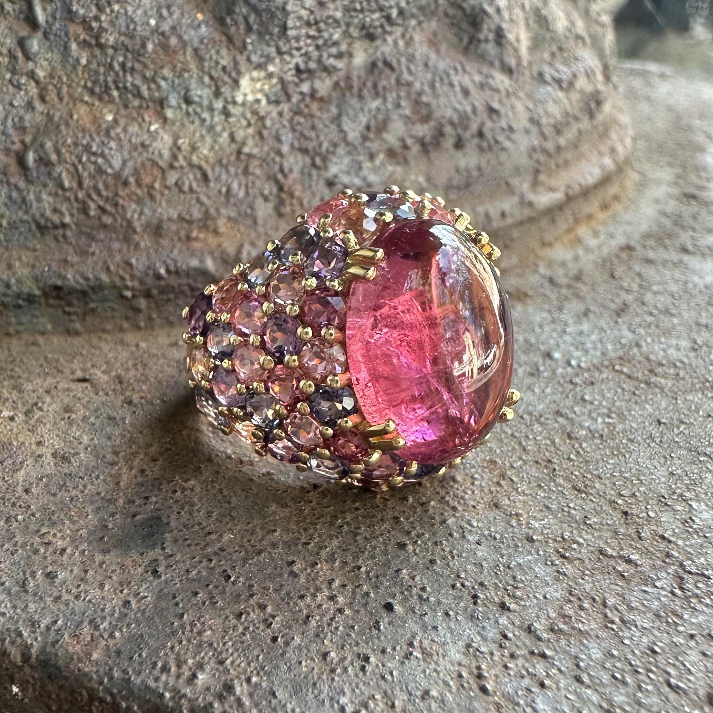 --Pierre(s) :...
(1) Tourmaline véritable naturelle - taille cabochon ovale - serti double - couleur rose vif - 8.20ct (approx.)
Nombreuses pierres roses et violettes véritables de Natura - taille ronde et brillante - serties en pavé - couleur rose