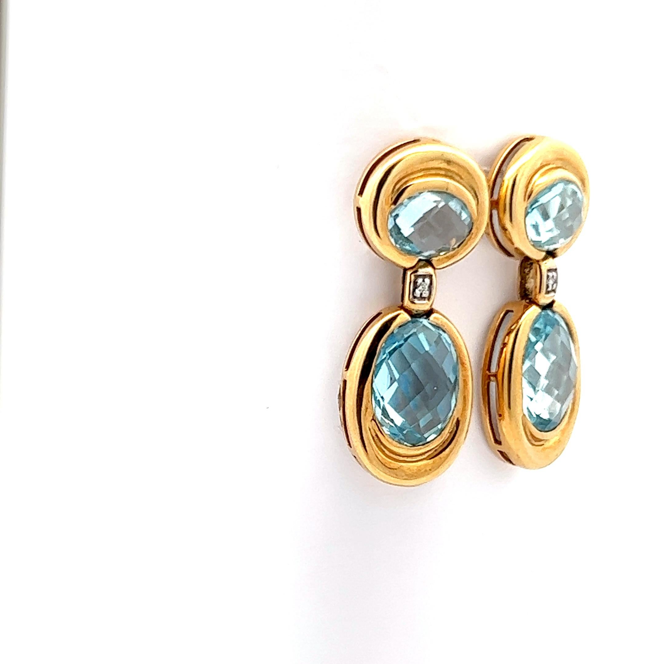 This is a gorgeous pair of contemporary aquamarine and diamond earrings made in 18k yellow gold. The earrings feature four = 10 cttw aquamarines with a beautiful blue hue, renascent of clear blue ocean waters. The earrings effortlessly capture