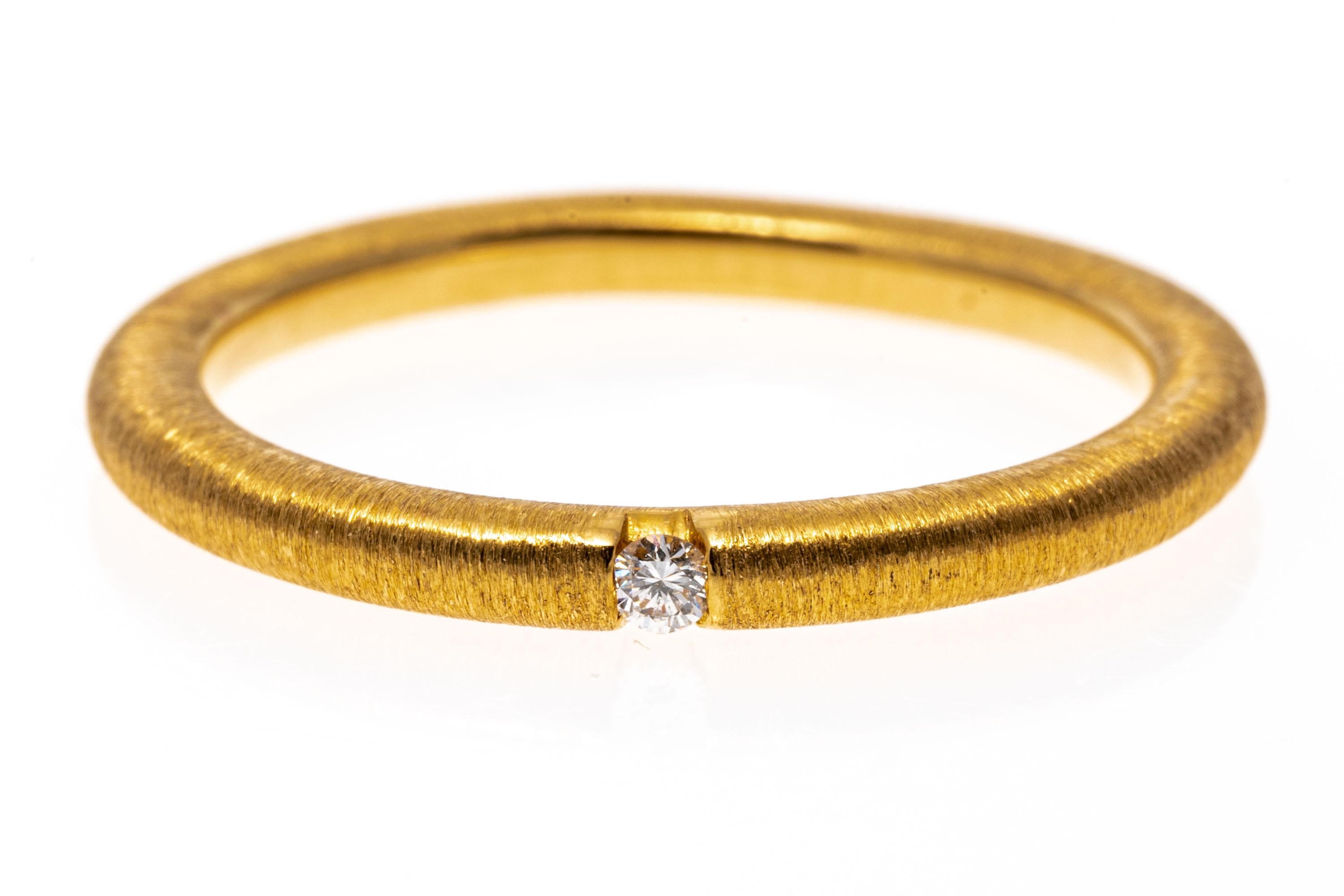 18k yellow gold ring. This beautiful, simple ring is a rounded, brushed finished band, flush set in the center with a small, round faceted accent diamond, approximately 0.02 CTS.
Marks: 18k
Dimensions: 1/16