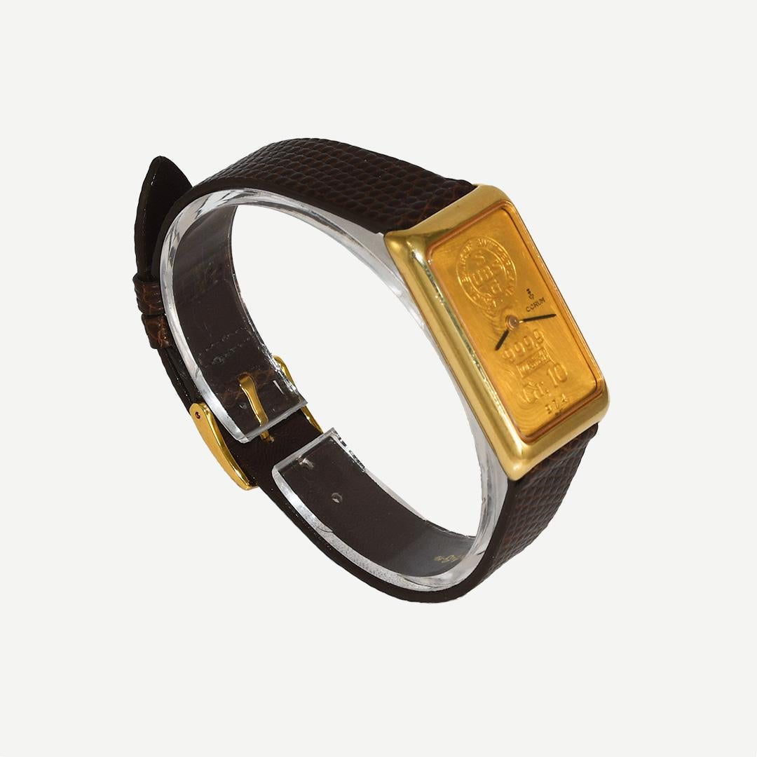 Unisex Corum 10 Gramm .999 Goldbarren Uhr mit 18k Gelbgold Fall.
Die Rückseite des Gehäuses ist mit 18k gestempelt.
Das Gehäuse ist 35 mm lang und 21 mm breit.
Das Uhrwerk ist ein Schweizer Präzisions-Handaufzugswerk mit 17 Steinen.
Zweimal täglich