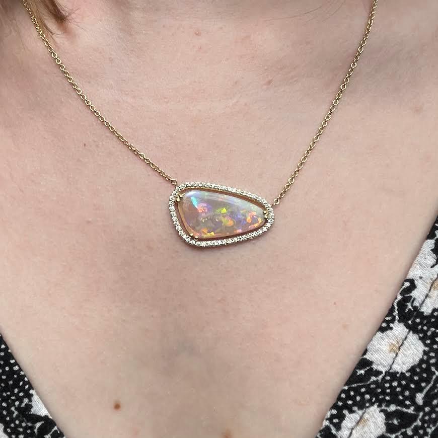 An 18k yellow gold necklace featuring one double prong set free formed Australian crystal opal 3.72 carats and accented by a halo of white diamonds 0.31 total carat weight on a 1.5mm 16 inch 14k yellow gold cable chain. This necklace was designed